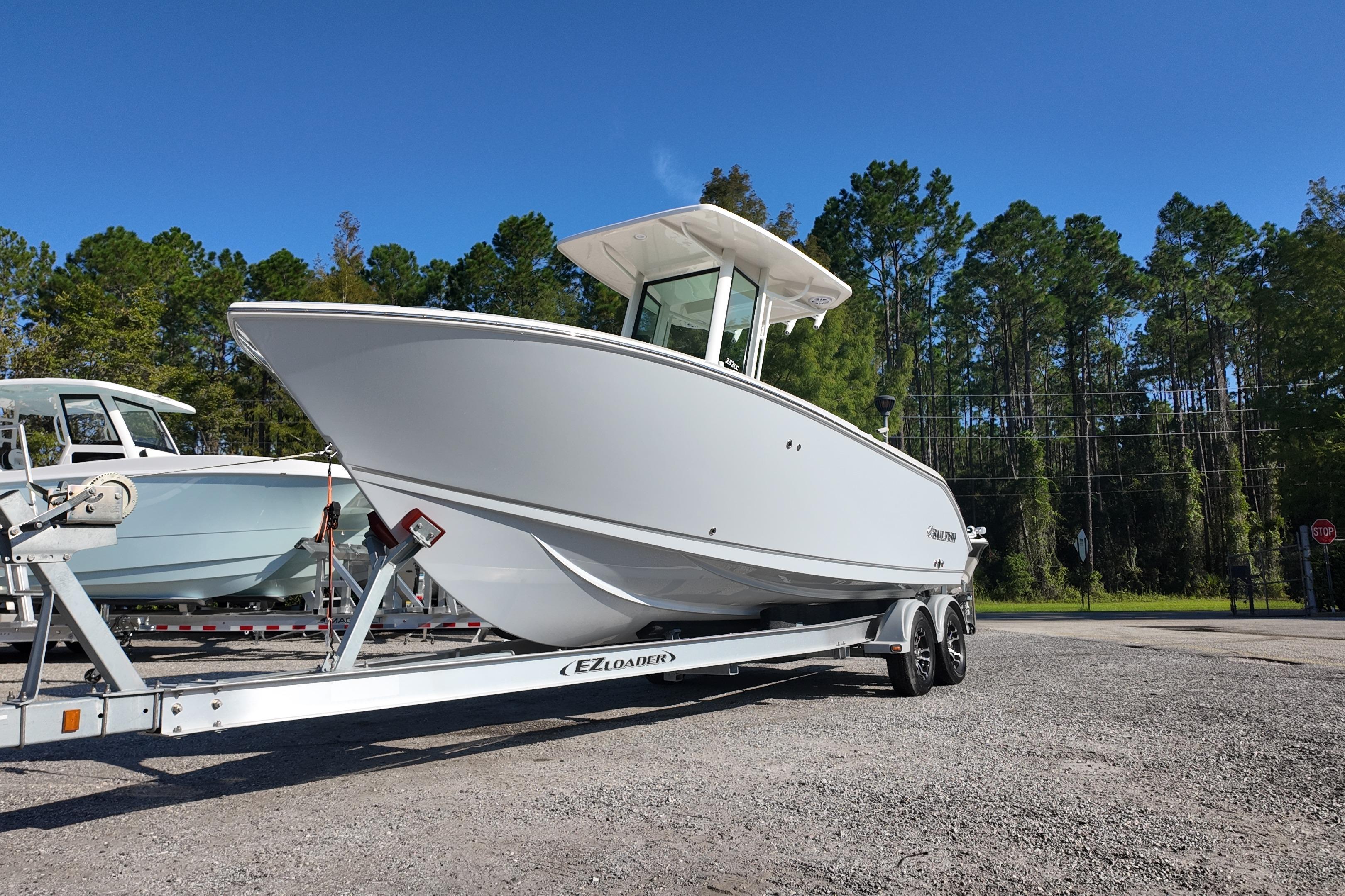 2026 Sailfish 232 CC boat on trailer, parked outdoors with trees in background.