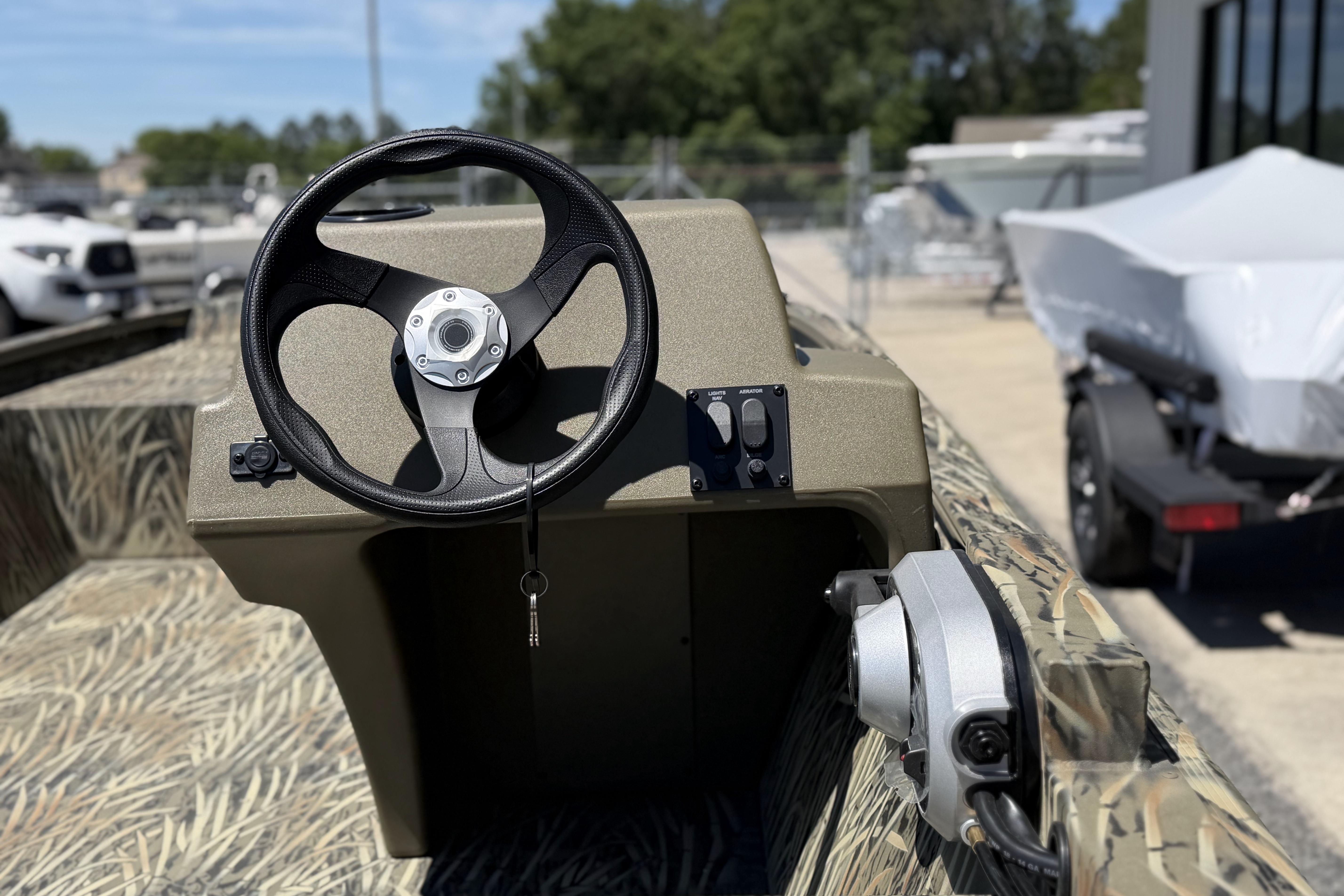 2026 Tracker Grizzly 1648 SC boat steering console with camouflage interior design.