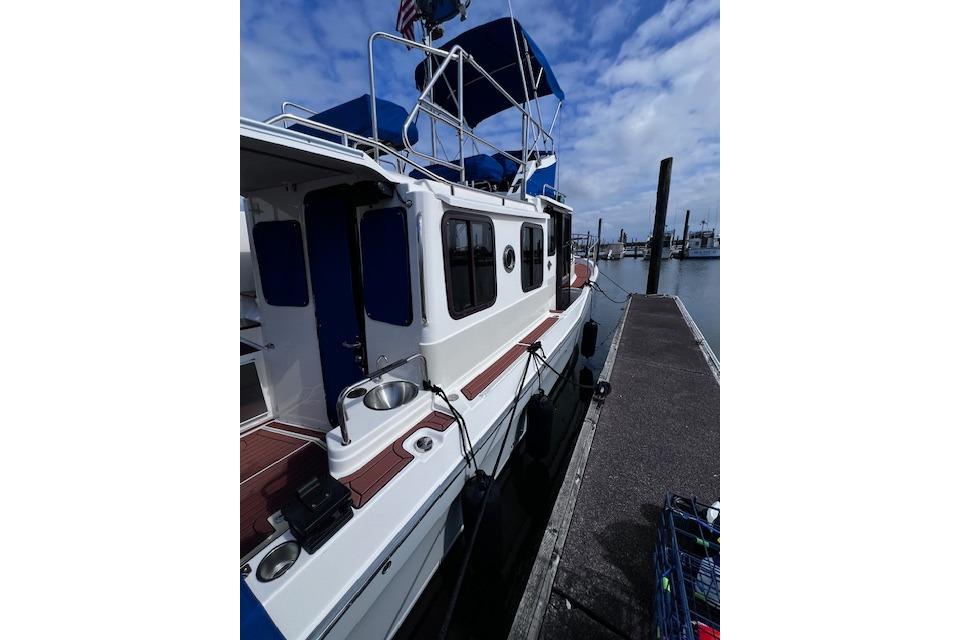 2021 Ranger Tugs R-31 CB docked at marina under blue sky.