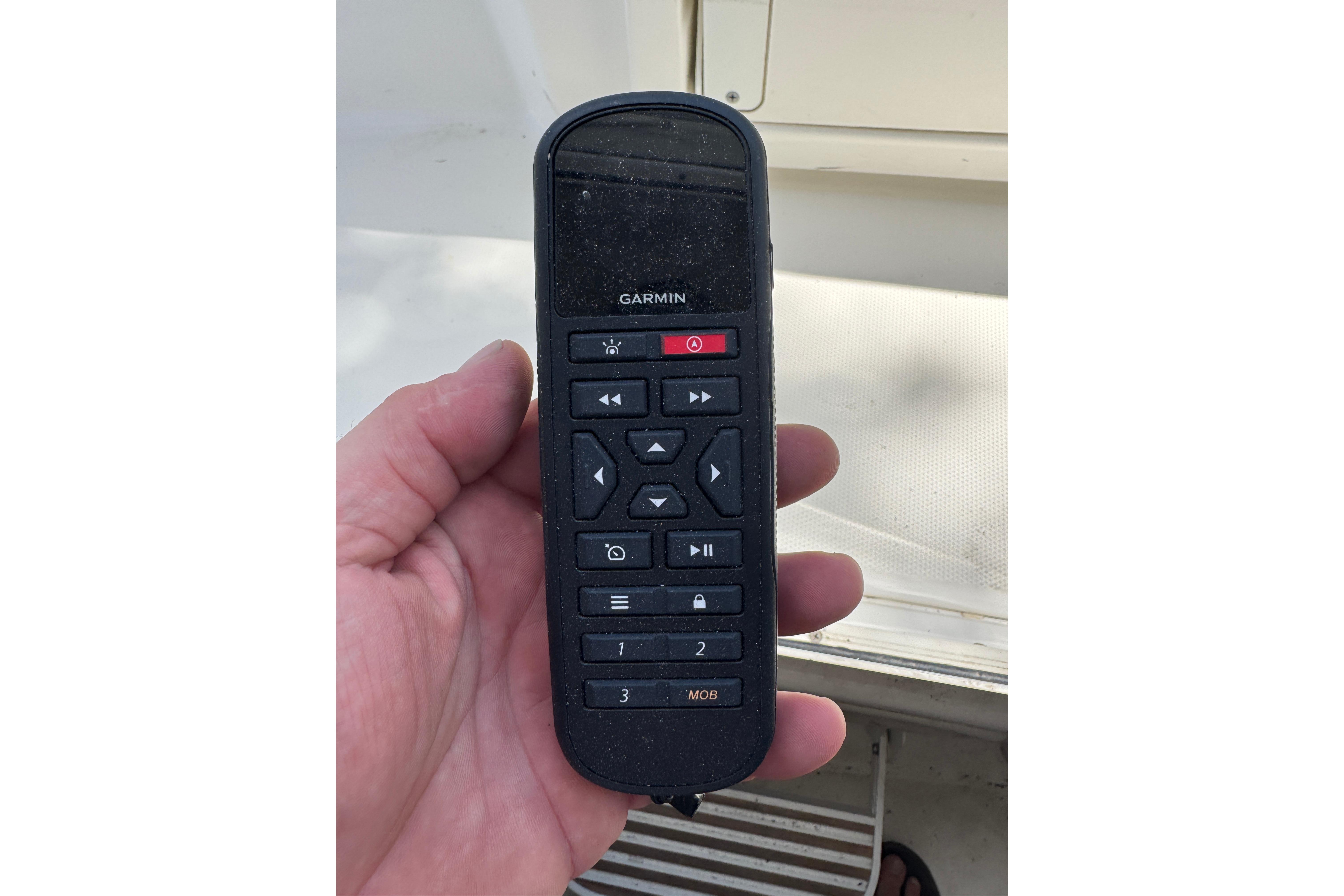 Hand holding a Garmin remote control on a 2014 Boston Whaler 250 Outrage boat.