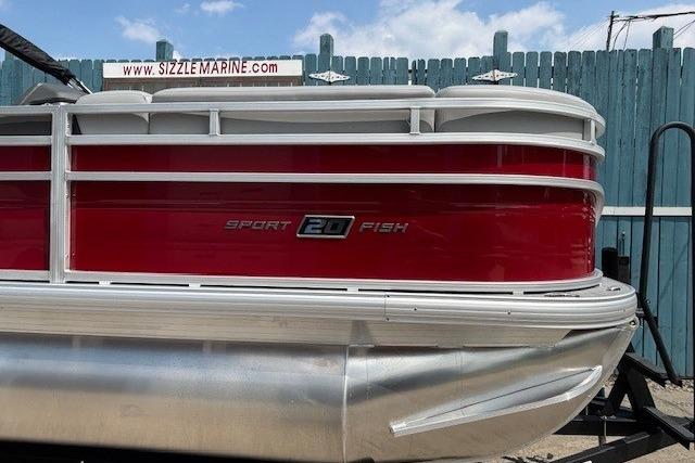 2026 Sun Tracker SportFish 20 DLX pontoon boat with red and white exterior.