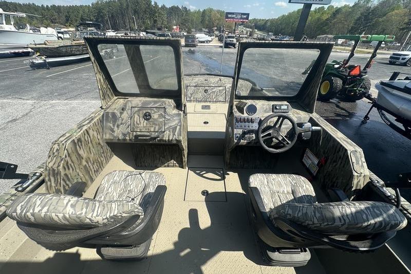 2025 SeaArk Predator 300 AK boat interior with camouflage seating and steering console.