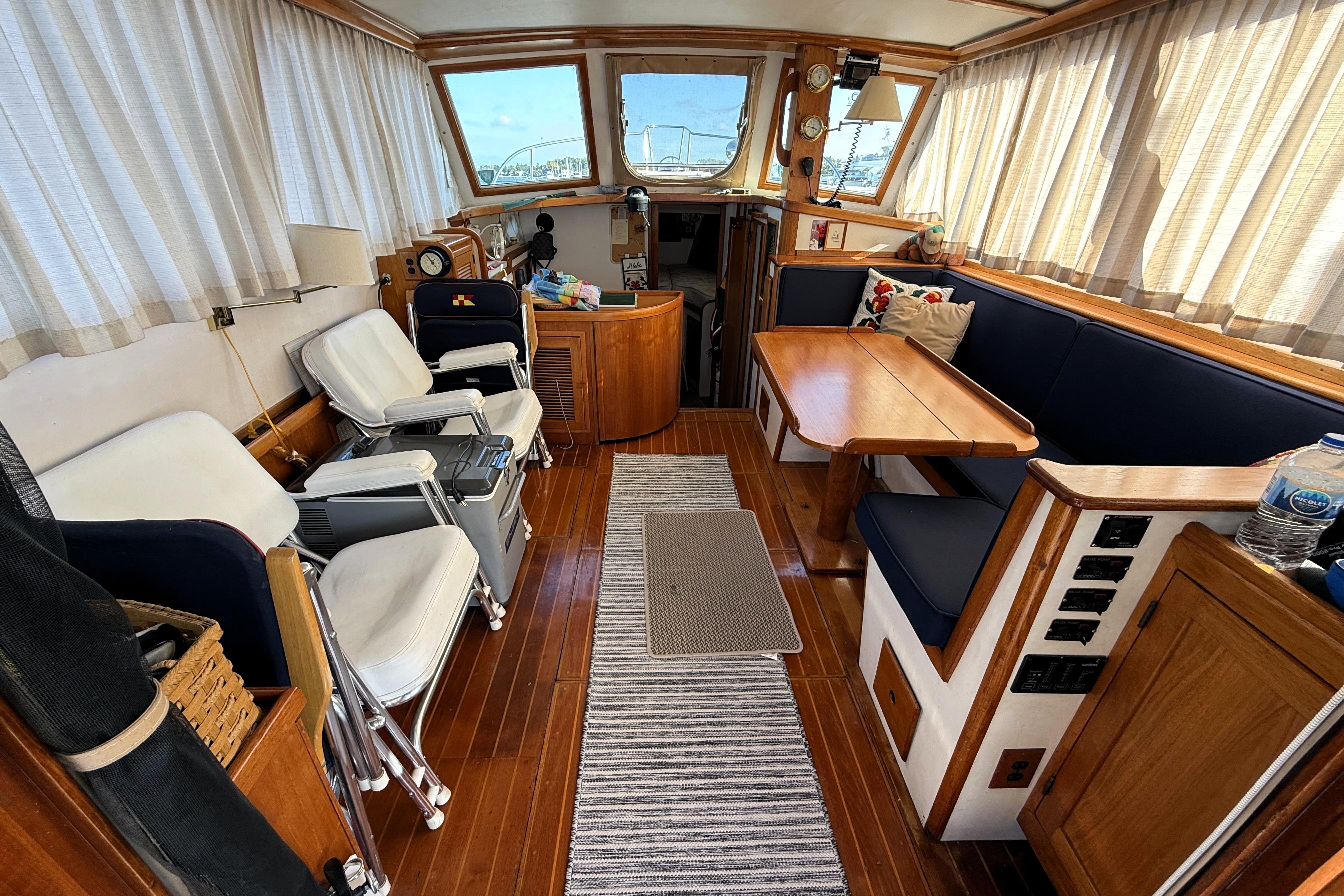 Interior of 1983 Wilbur 34 Fly Bridge Cruiser with wooden furnishings and seating.