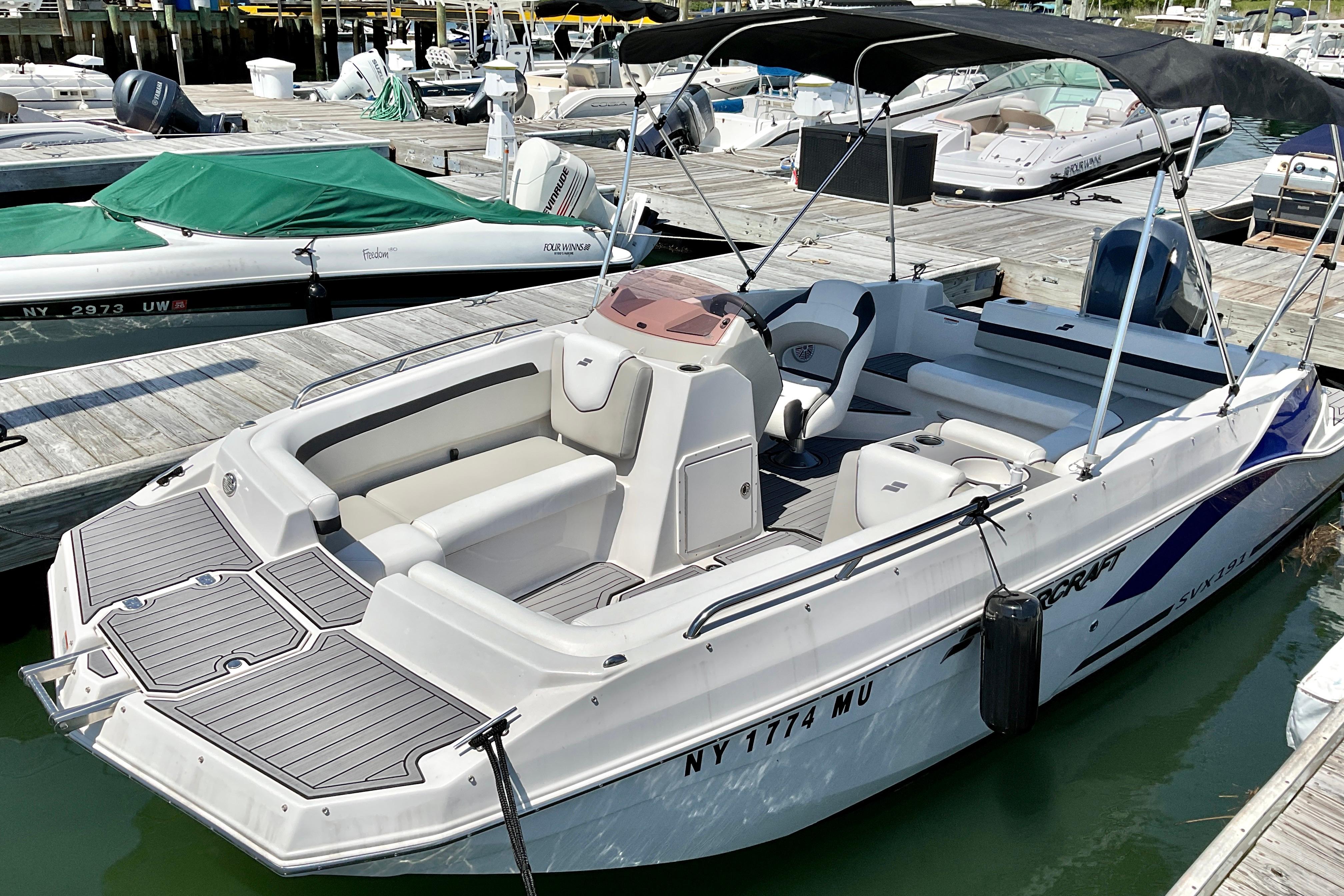 2023 Starcraft SVX 191 OB boat docked at marina, featuring sleek design and spacious seating.
