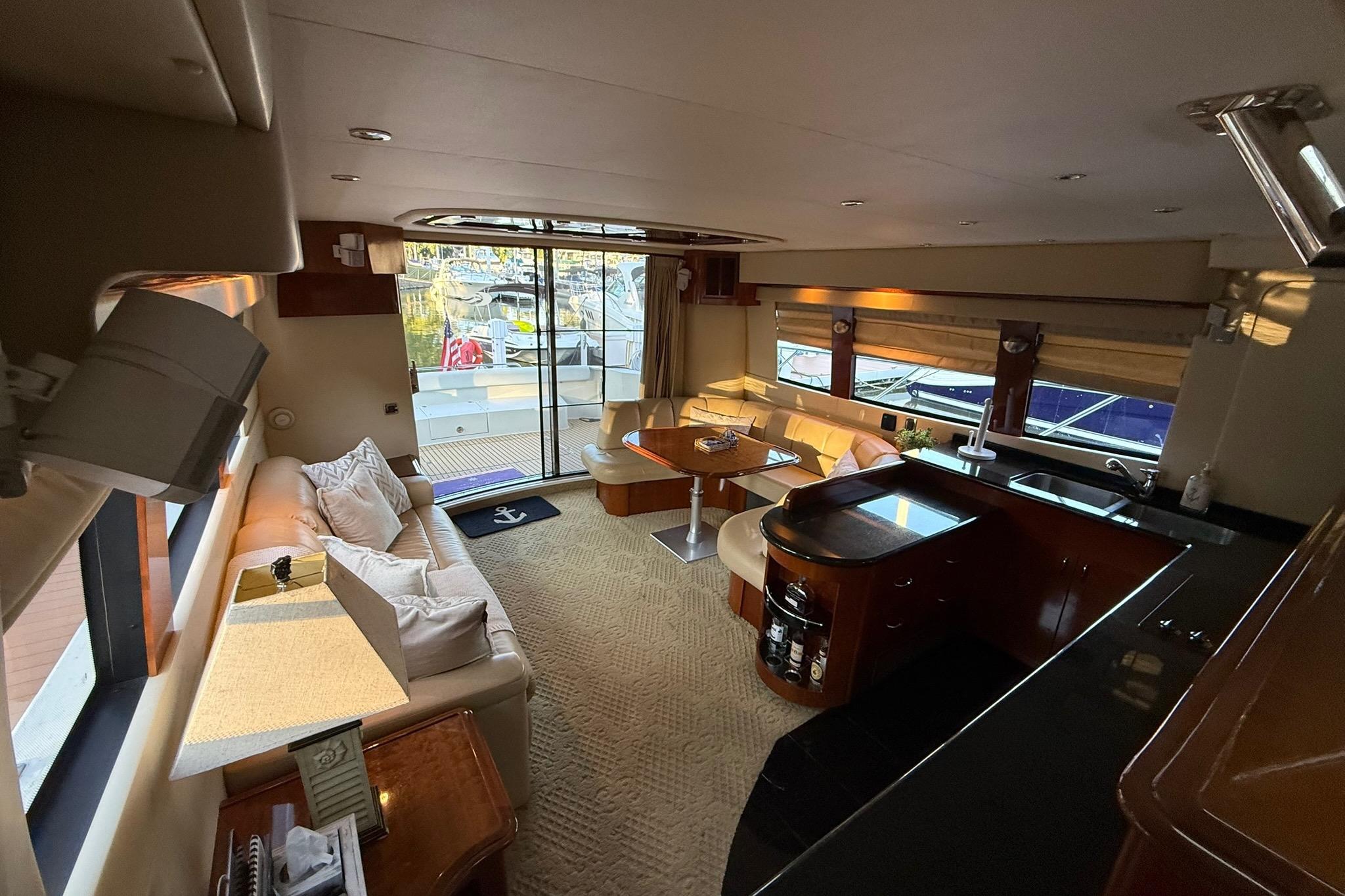 Luxurious interior of a 2006 Carver 56 Voyager yacht with elegant seating and kitchen area.