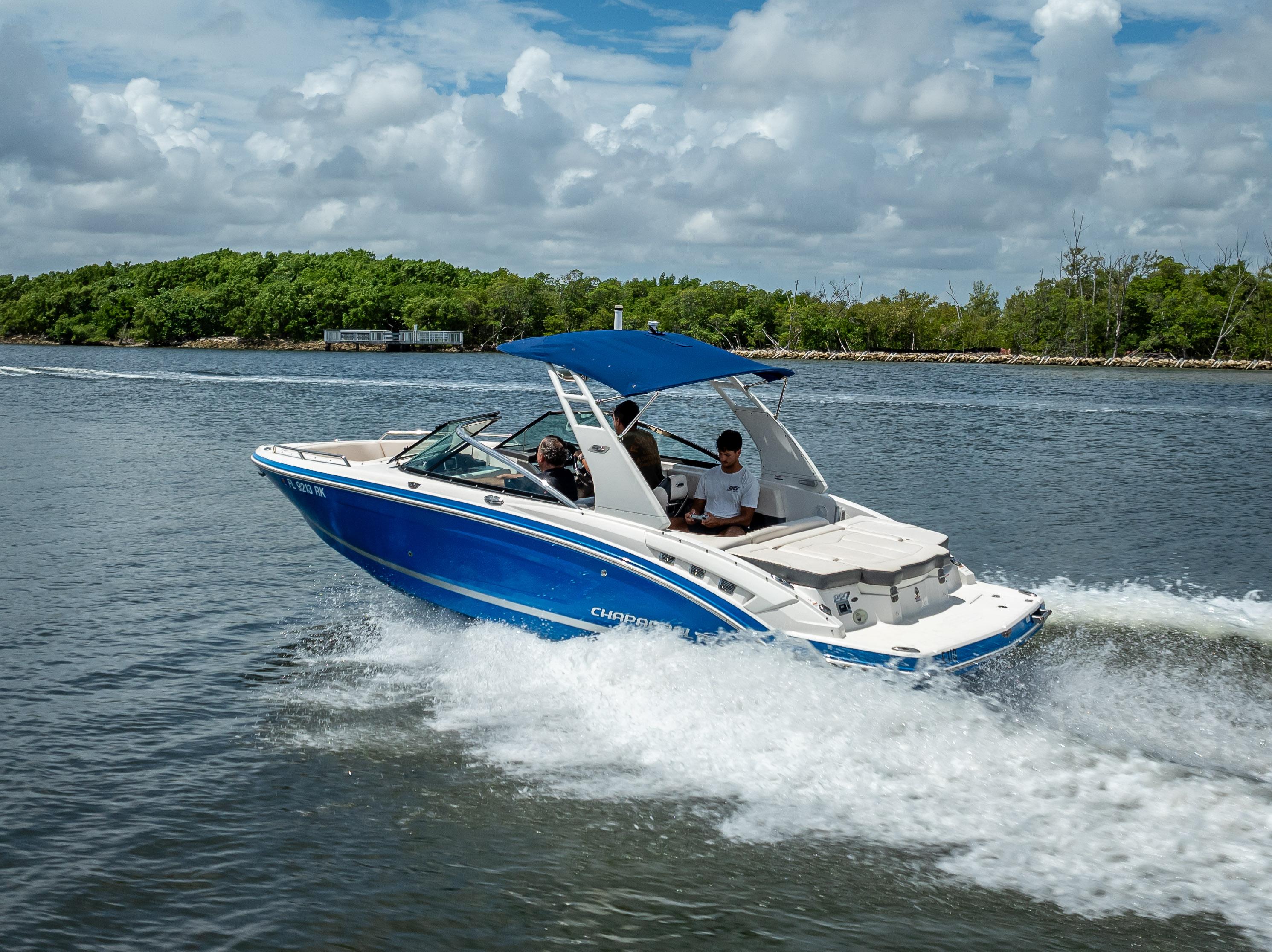 2017 Chaparral 227 SSX boat cruising on a scenic waterway under a cloudy sky.