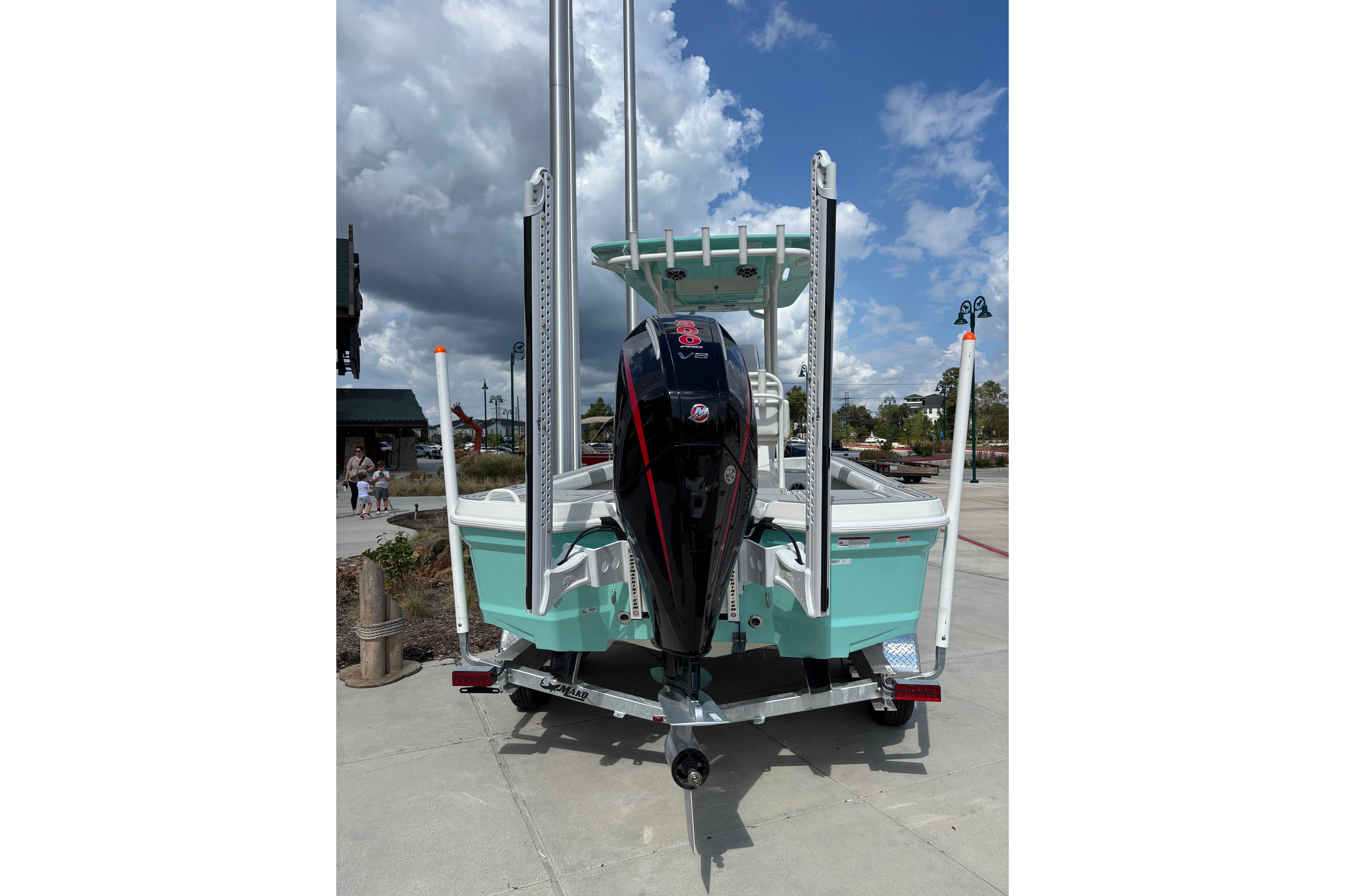 2026 Mako 24 APEX boat with outboard motor, parked on a sunny day.