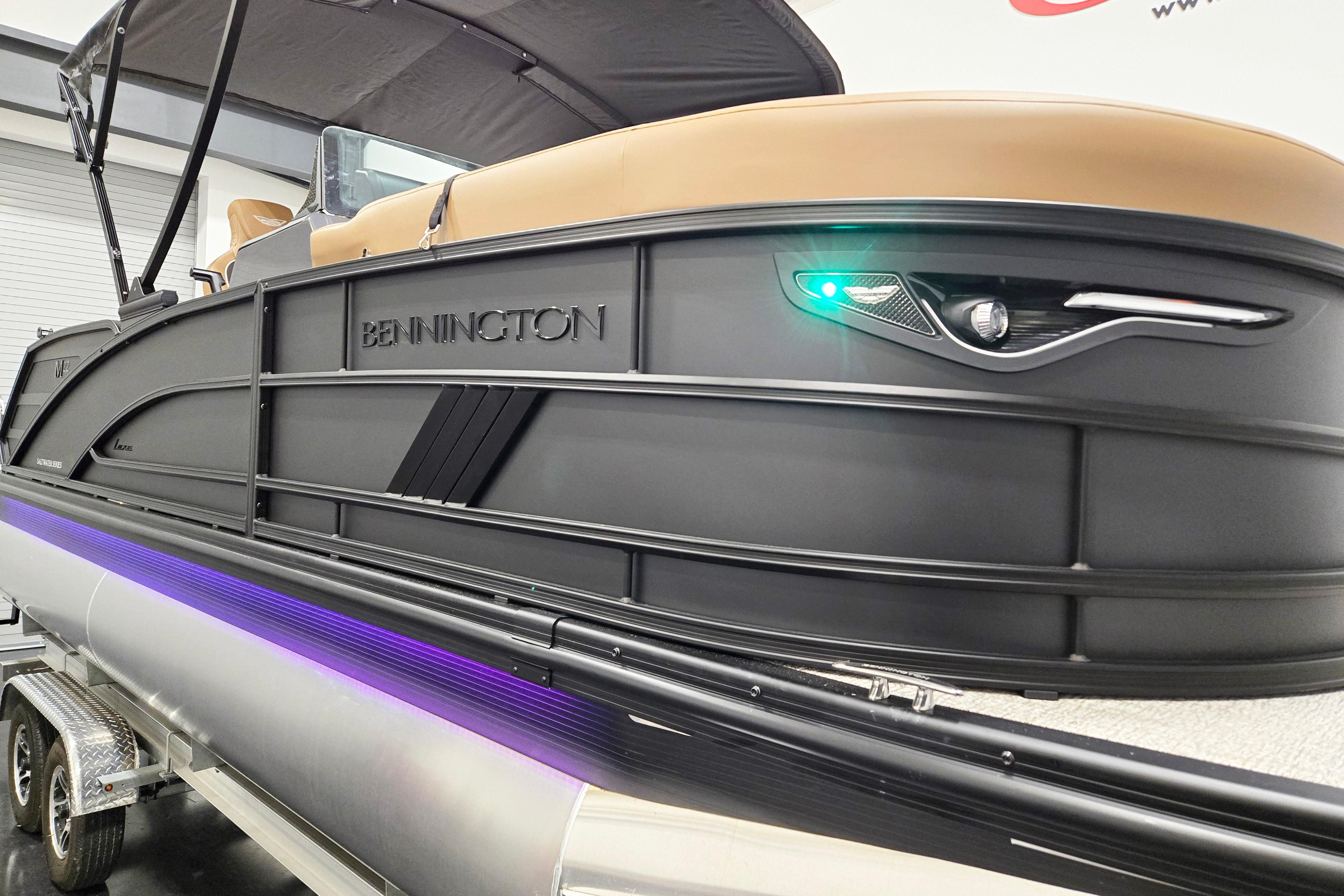2026 Bennington 22 M Swingback pontoon boat with sleek black design and LED lighting.
