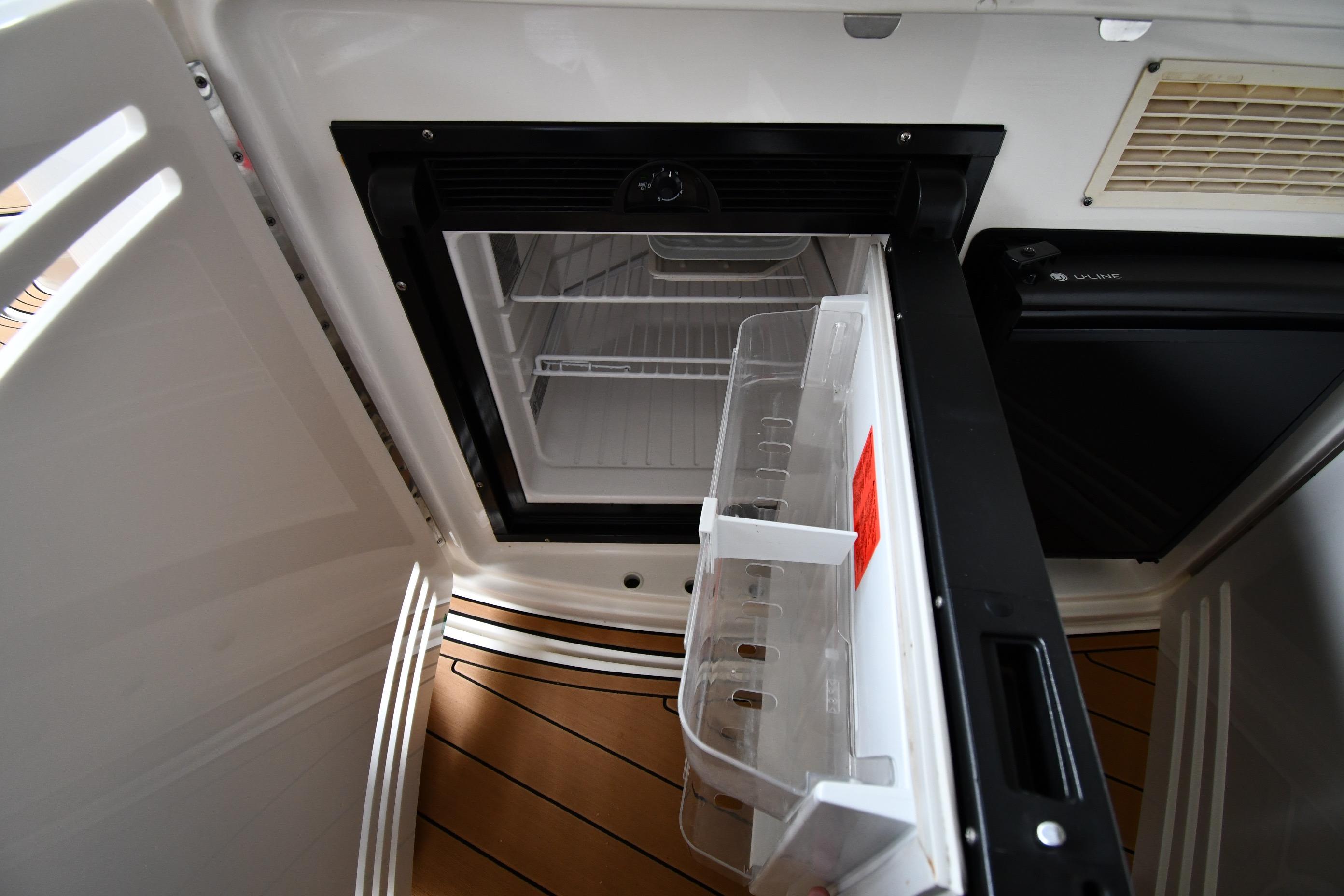 Open refrigerator on 2001 Sea Ray 540 Sundancer yacht, showcasing interior storage space.