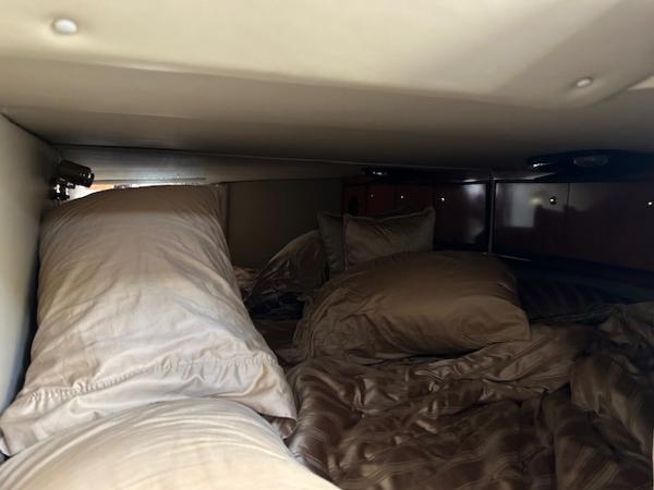 Interior cabin of 2008 Fountain 38 Sportfish Express Cruiser with cozy bedding.