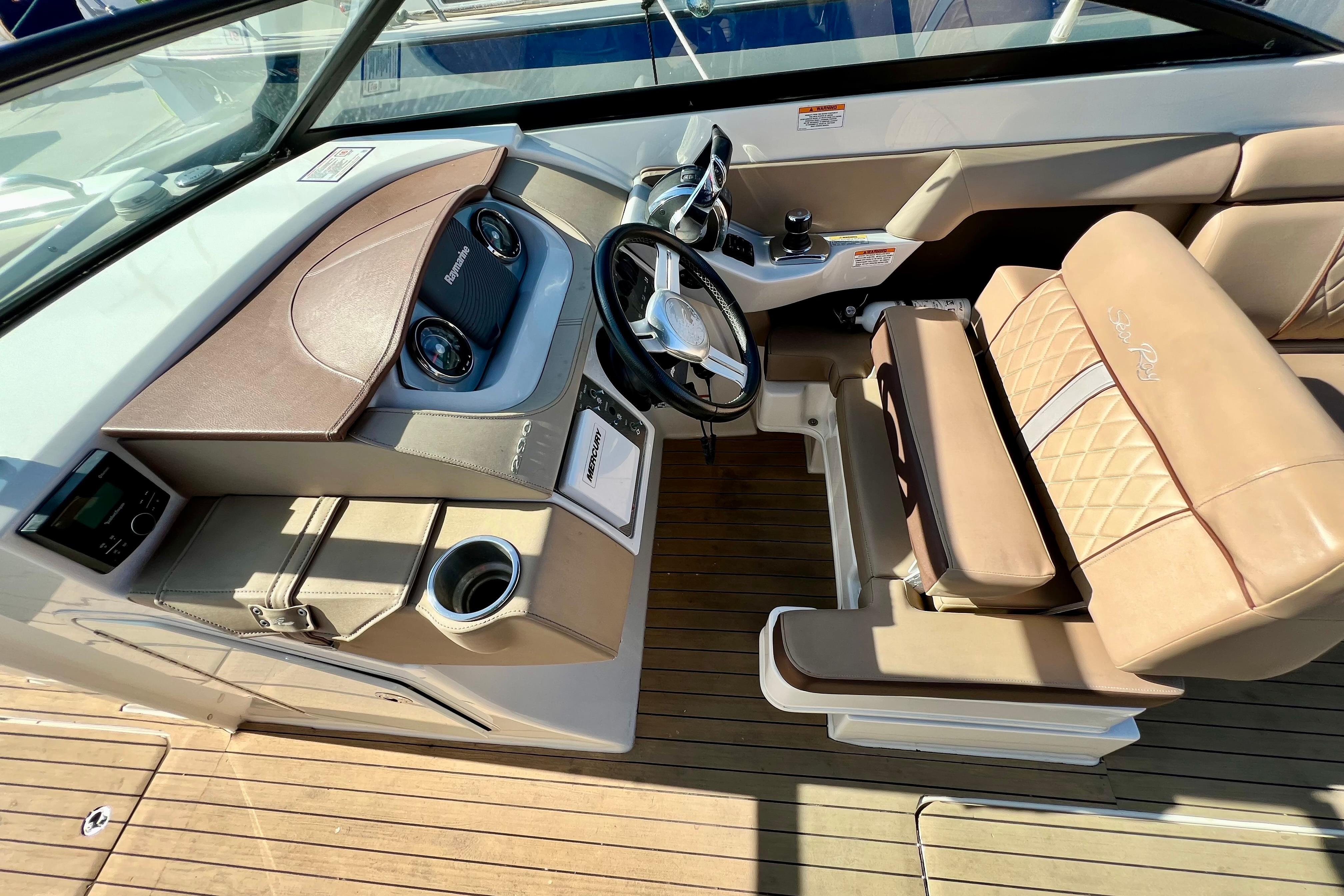 2016 Sea Ray 290 Sundeck Outboard helm with tan seating and modern dashboard.