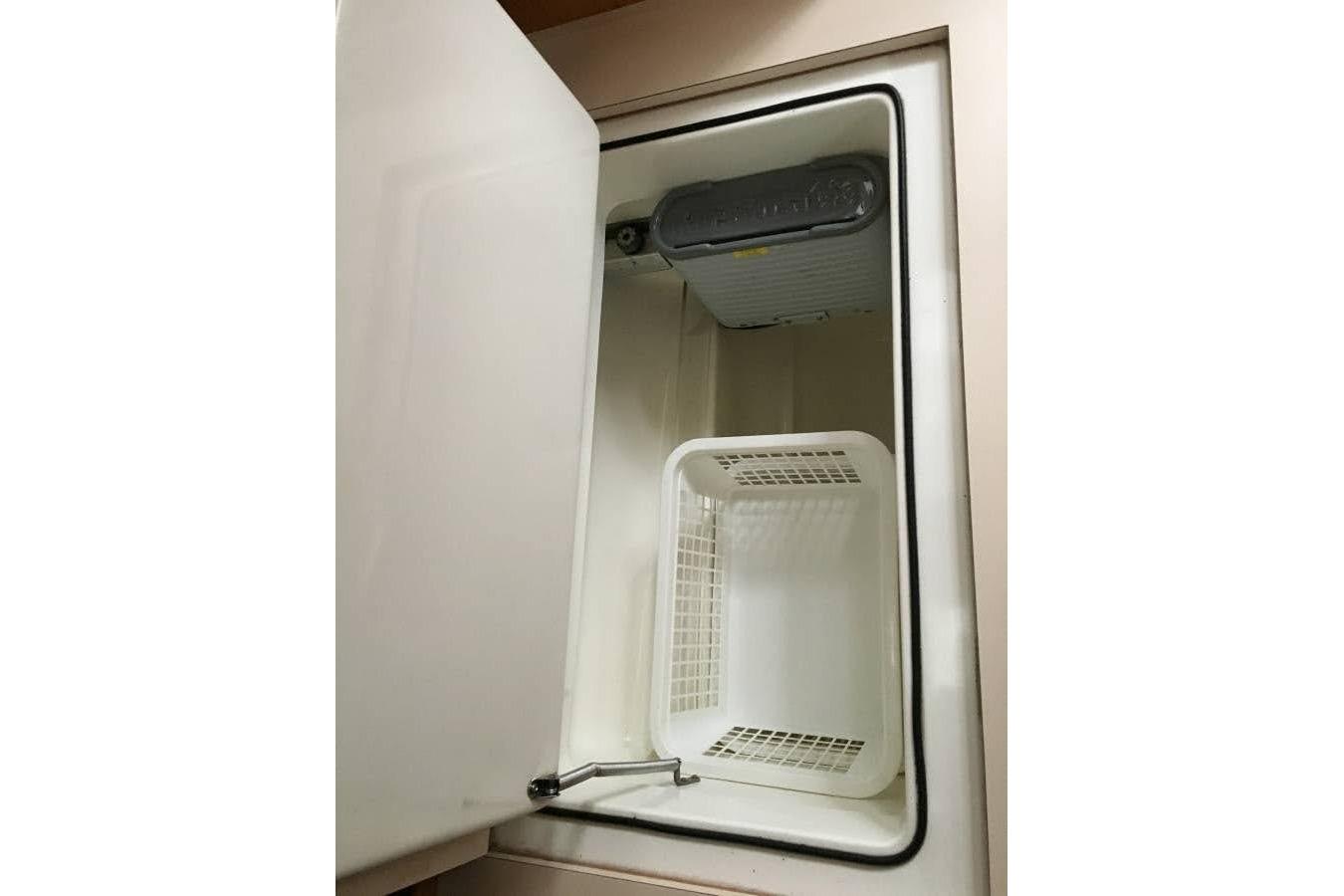 Open storage compartment on 1991 Beneteau Oceanis 350 yacht, featuring a white basket.
