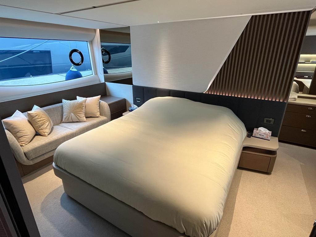 Luxurious bedroom interior of 2021 Princess Y72 yacht with modern design and cozy seating area.