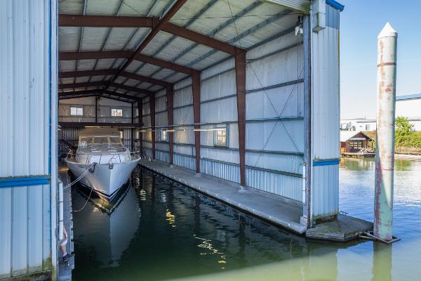Custom 1985 Larson Boathouse with docked boat in sheltered marina setting.