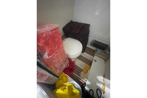 2015 Scout 255 LXF boat interior with toilet and storage items.