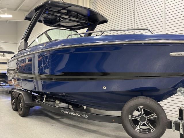 2026 Chaparral SSX 6 boat in showroom, sleek blue design on trailer.