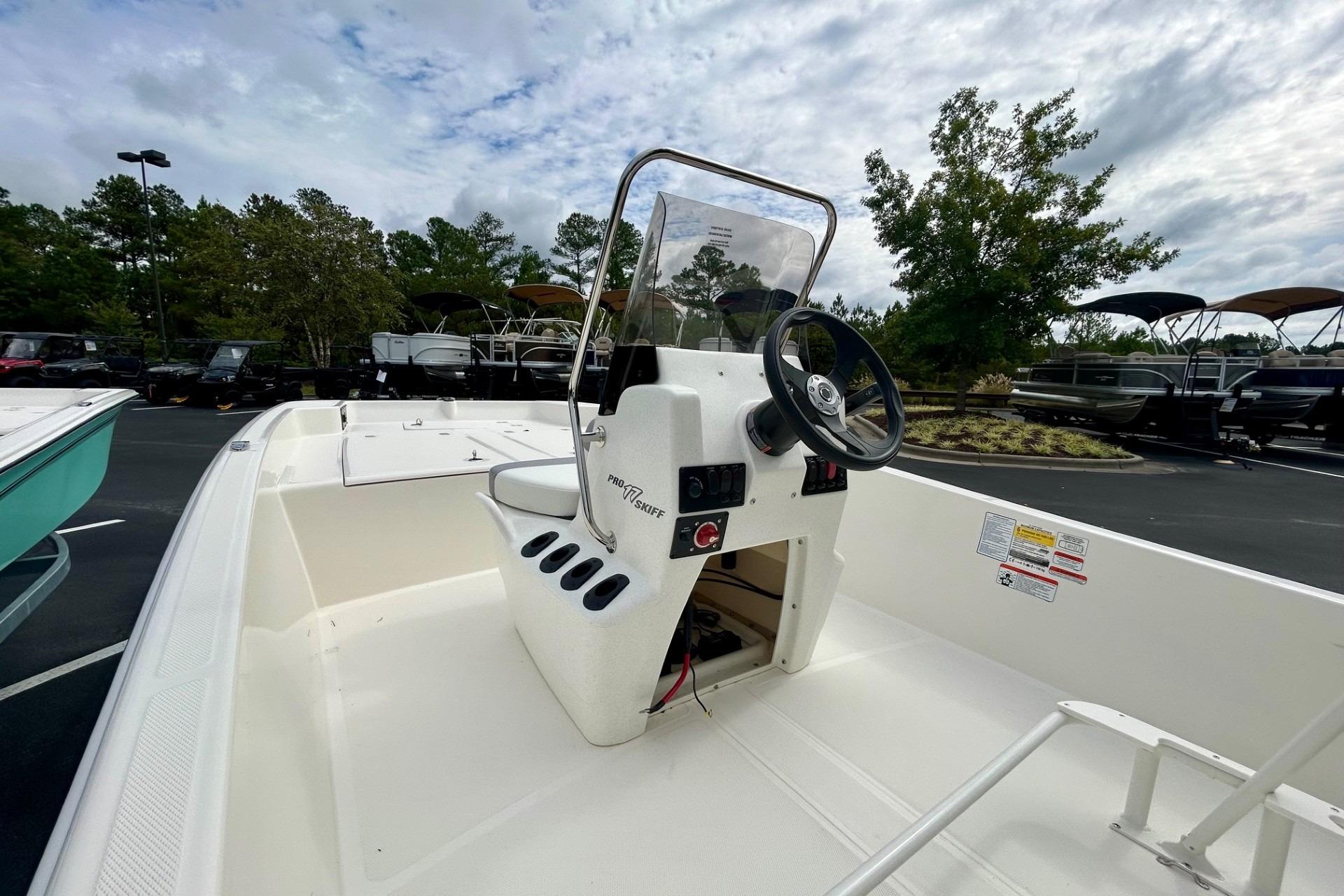 2026 Mako Pro Skiff 17 CC boat with center console and steering wheel, parked outdoors.