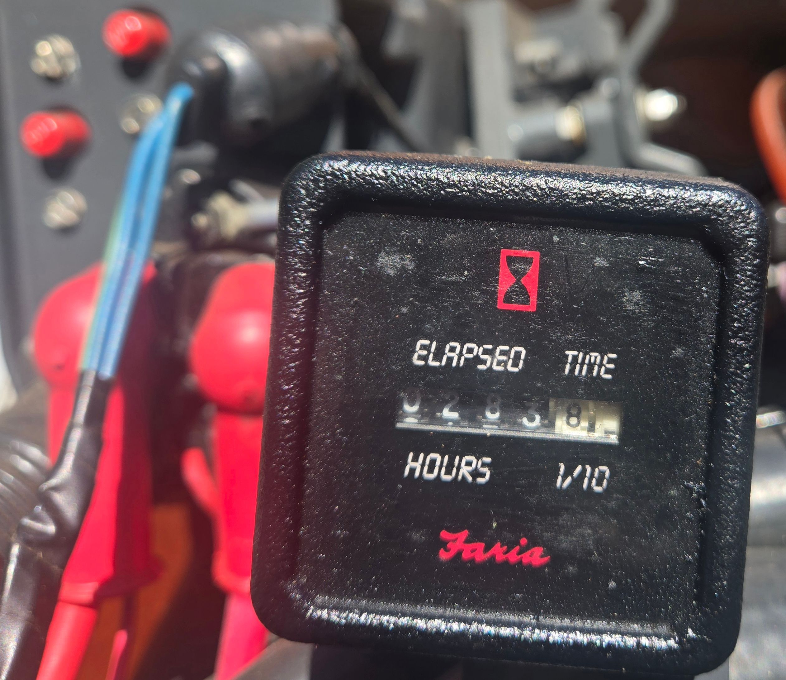 Close-up of an hour meter with red and blue wires in the background.