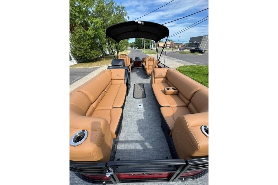2026 Regency 230 DL pontoon boat with tan seating and canopy on a sunny day.
