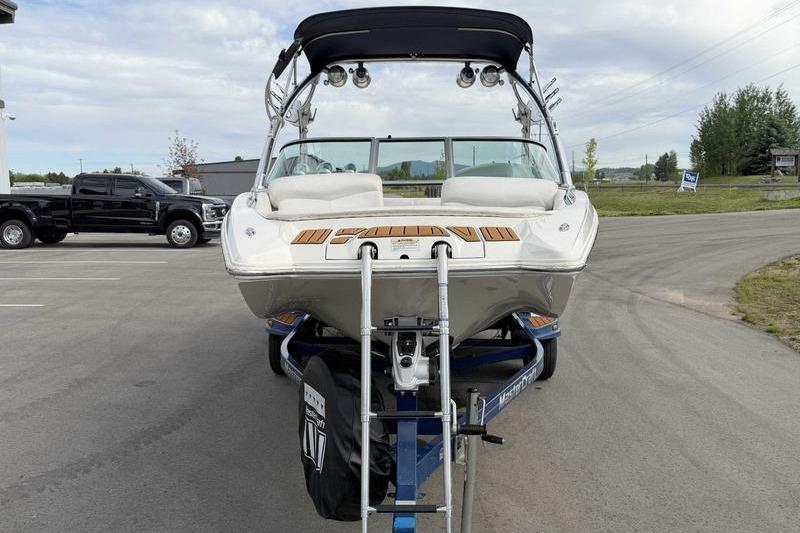 2004 MasterCraft XStar boat on trailer, parked outdoors with a truck nearby.