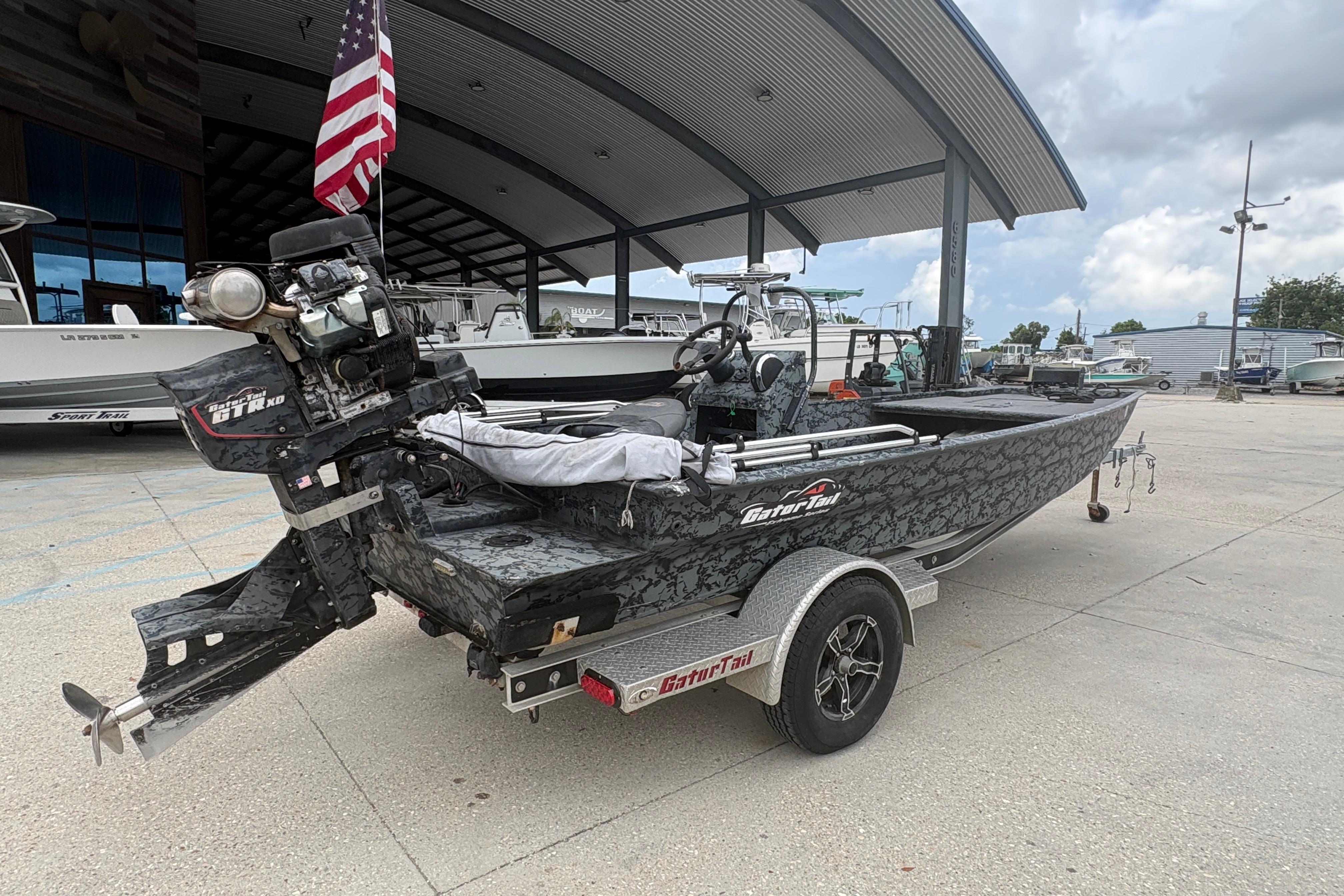 2020 Gator Tail Extreme boat on trailer, parked under a metal canopy with American flag.