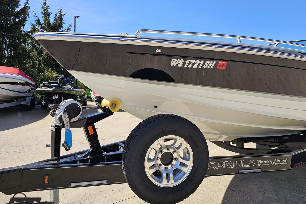 2014 Formula 292 FASTech boat on trailer, parked outdoors under clear blue sky.