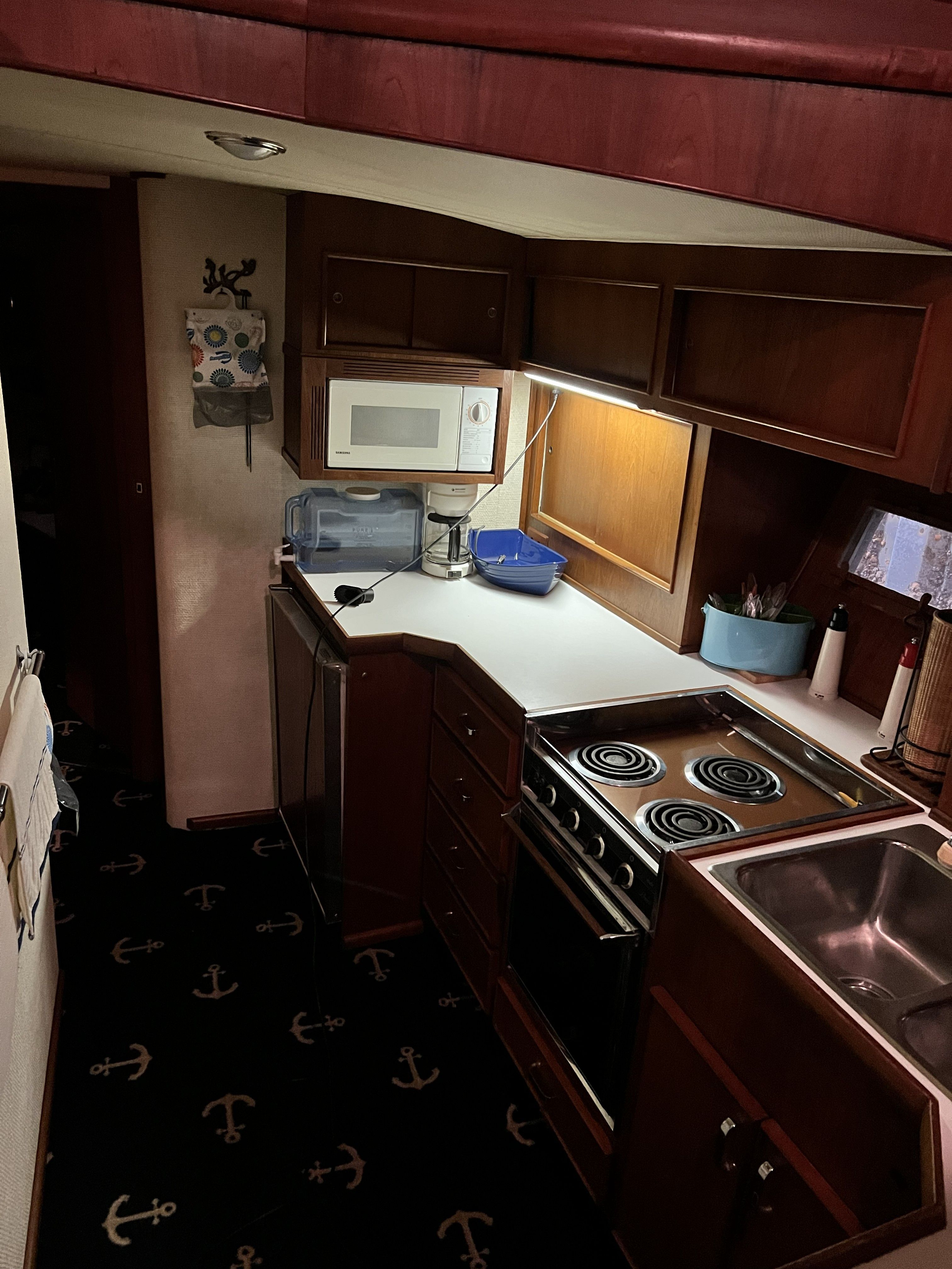 The galley of a 1979 Chris-Craft 45 TF with stove, sink, and microwave.