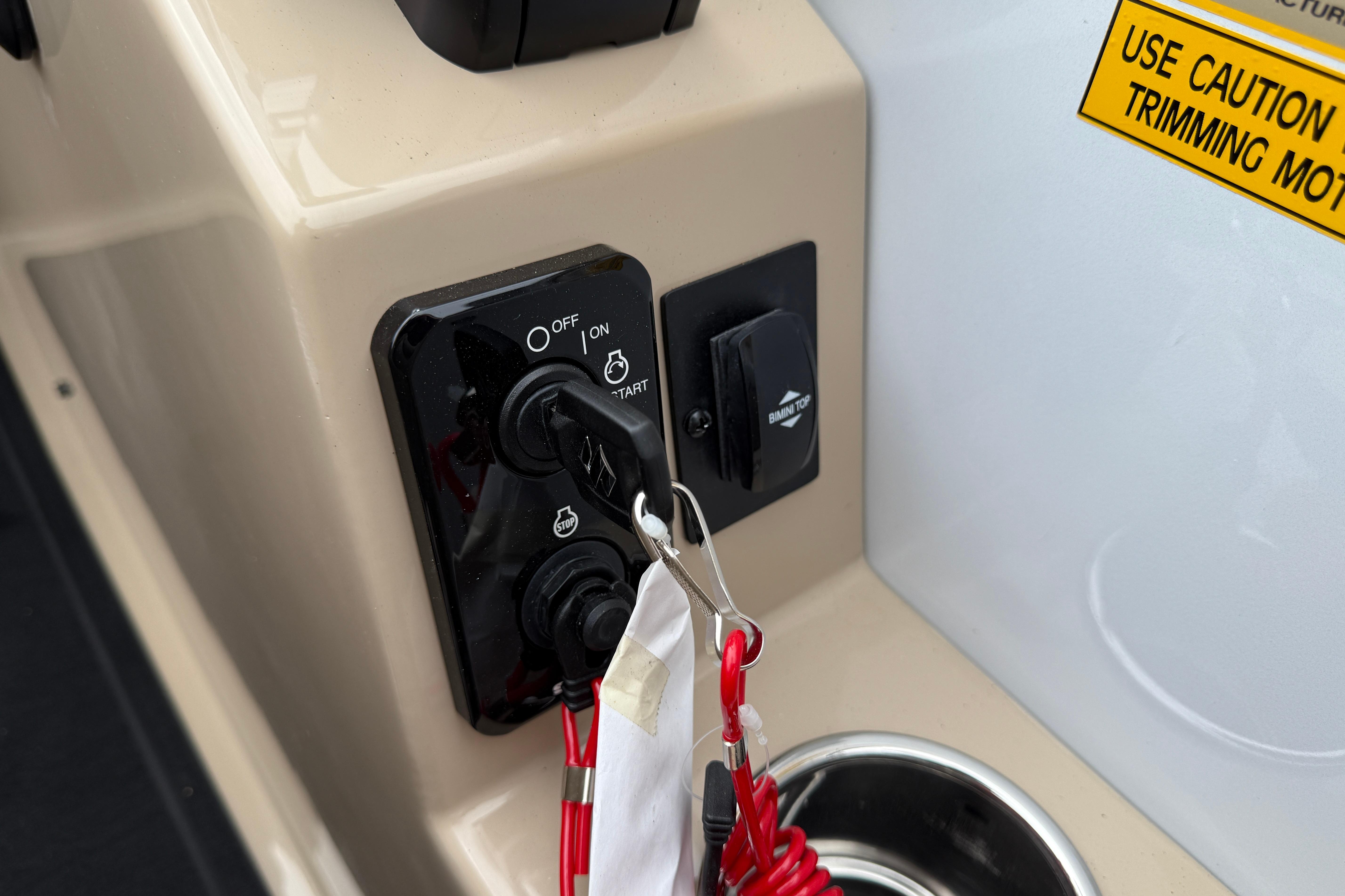 Control panel of 2026 Bentley Pontoons Elite 253 Admiral with ignition switch and caution label.