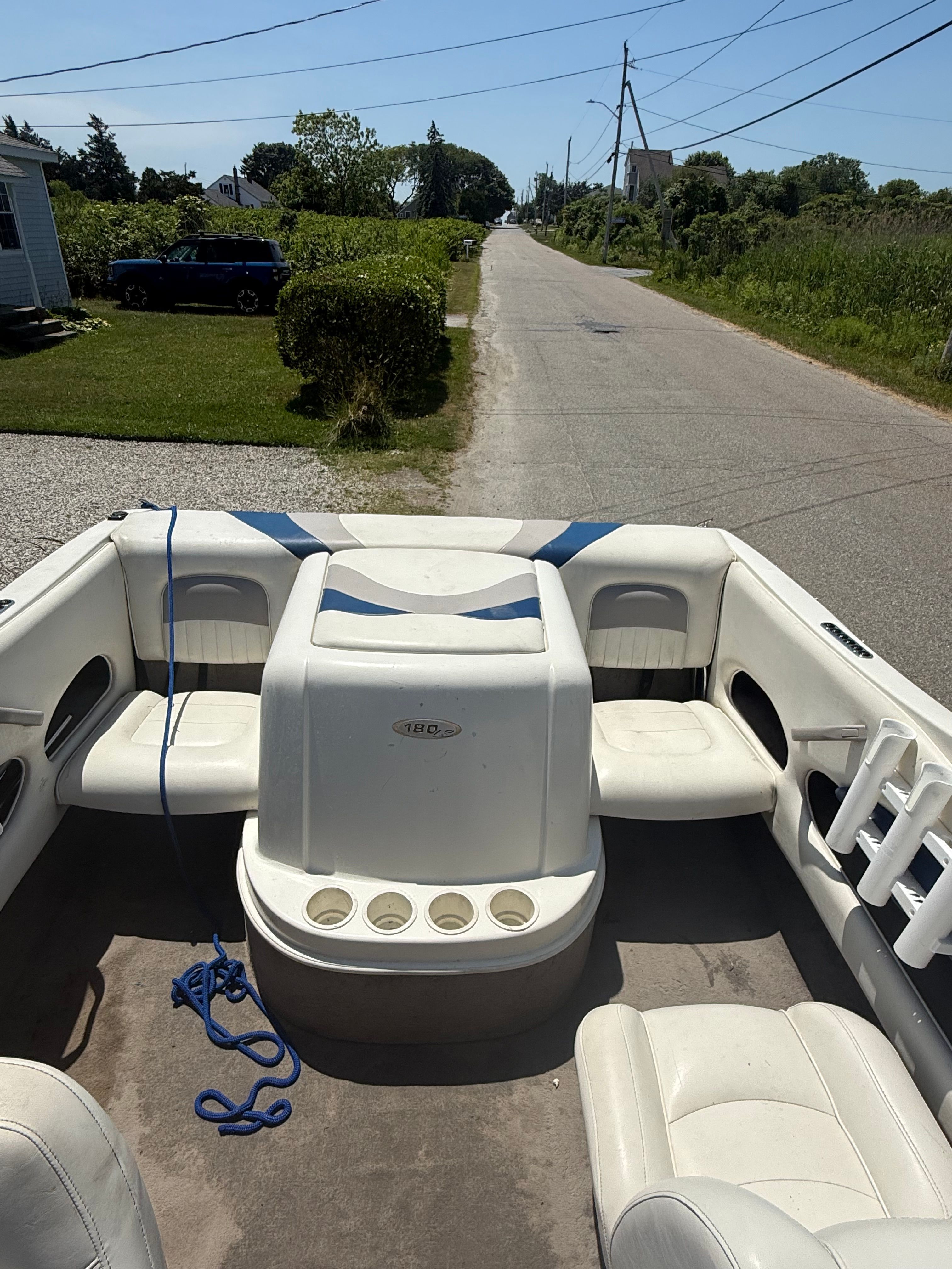 The image shows the cockpit of a 2003 Stingray 180 LS/LX boat on a road.