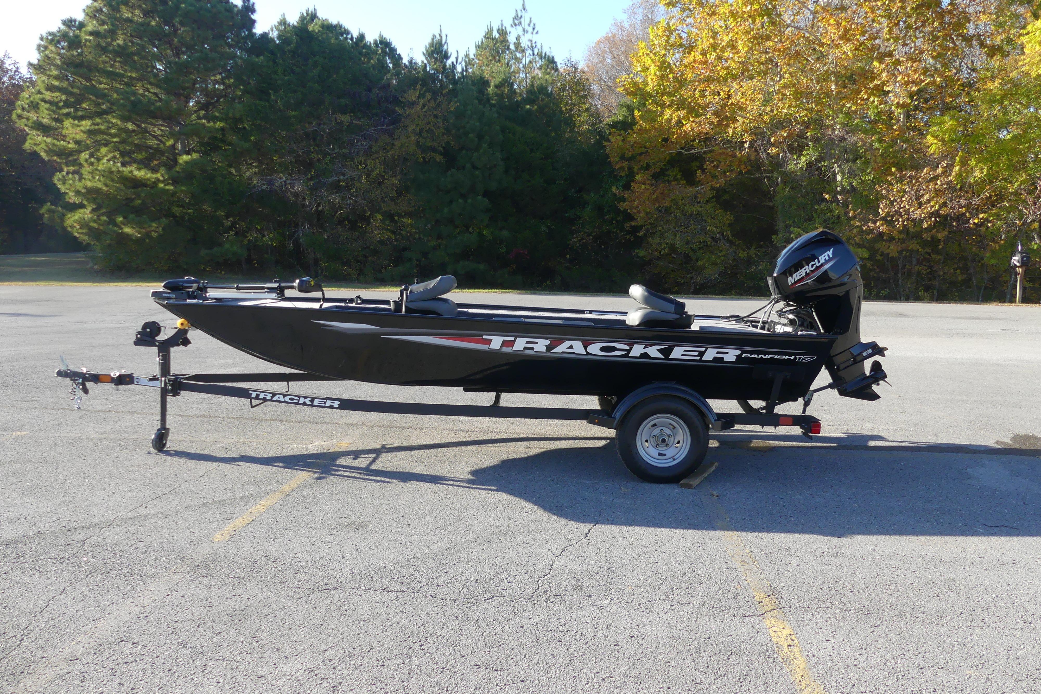 2025 Tracker Panfish 17 boat on trailer in parking lot, surrounded by trees.
