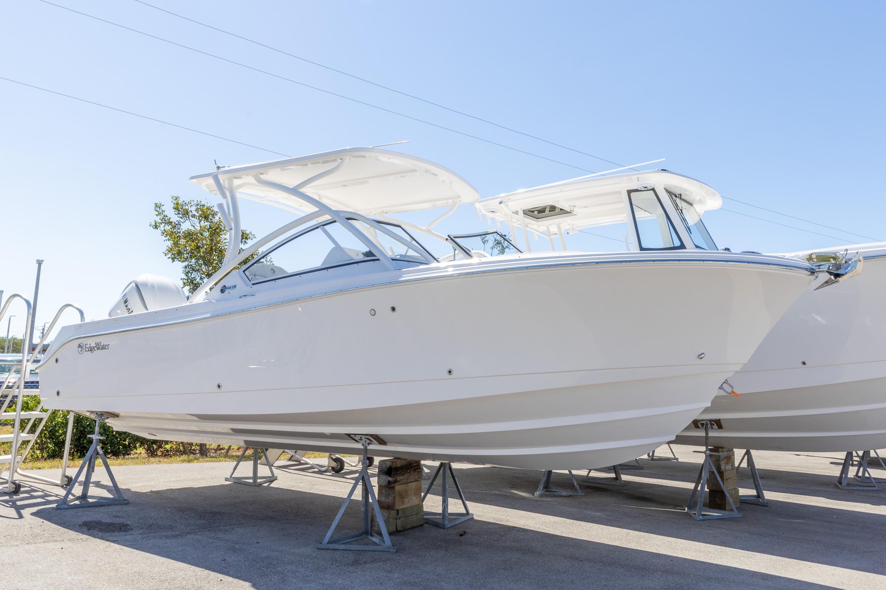 2026 Edgewater 248CX Crossover boat displayed on stands under clear blue sky.