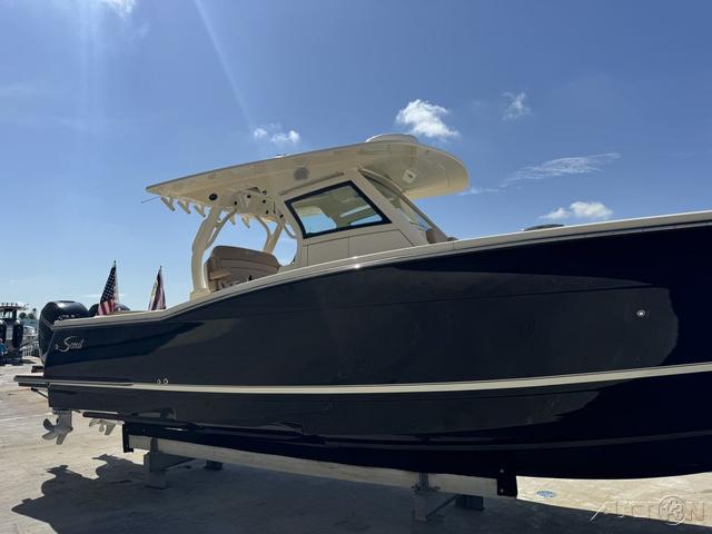 2022 Scout 330 LXF boat with hardtop, docked under a clear blue sky.