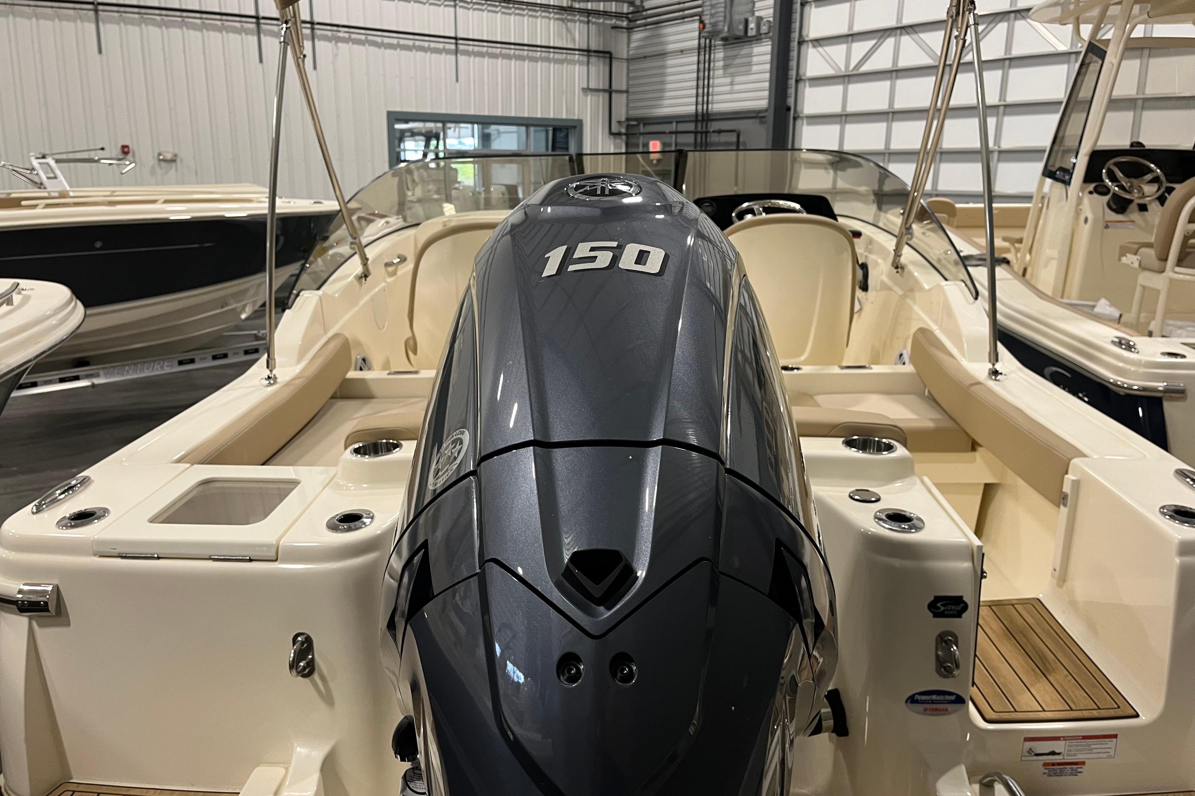 2025 Scout 215 Dorado boat with powerful 150 engine in showroom.