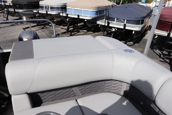 2024 Bennington 20 SL pontoon boat with cushioned seating, docked among covered boats.