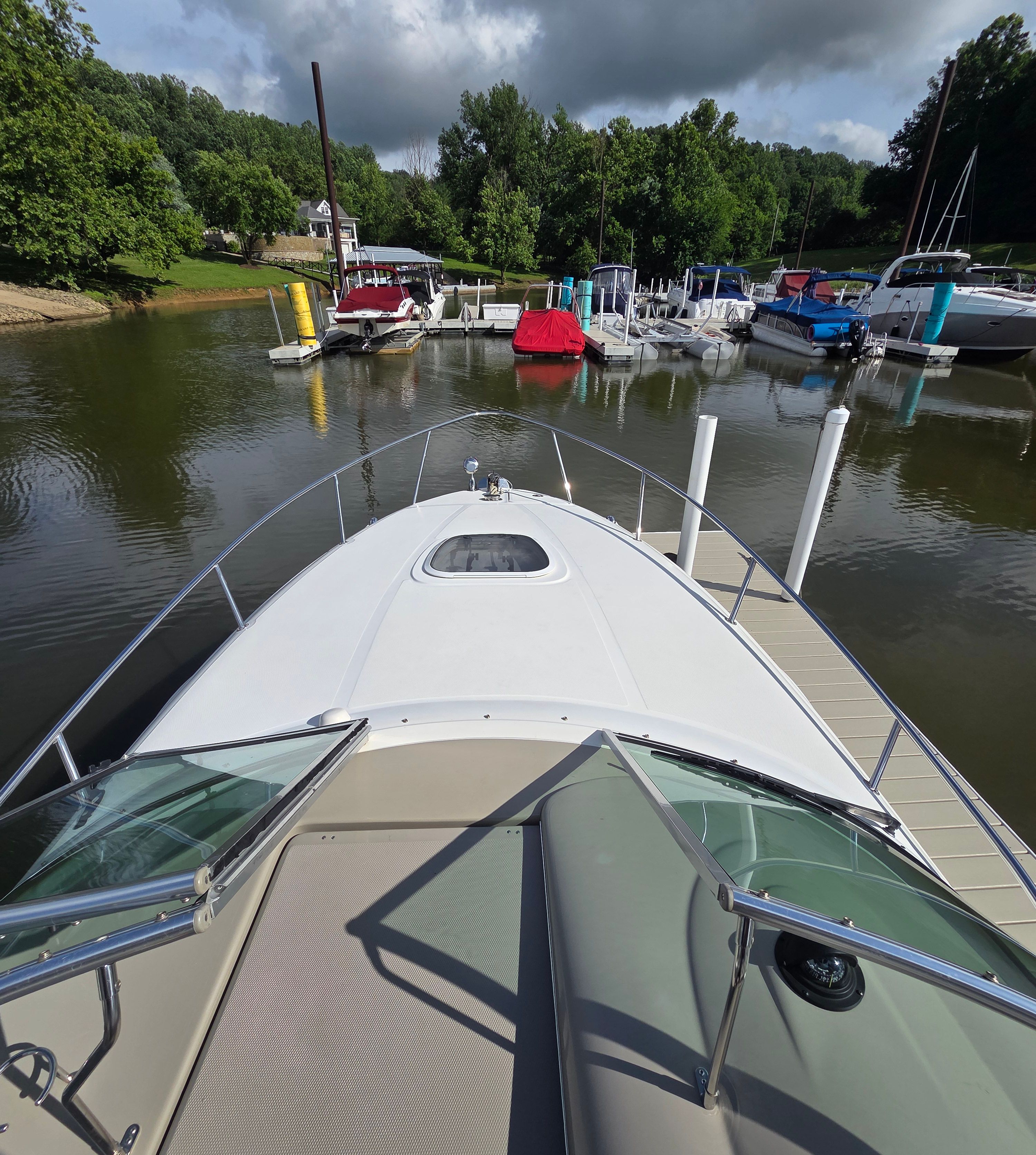 View from the bow of a Sea Ray Sundancer 260 in a calm marina.