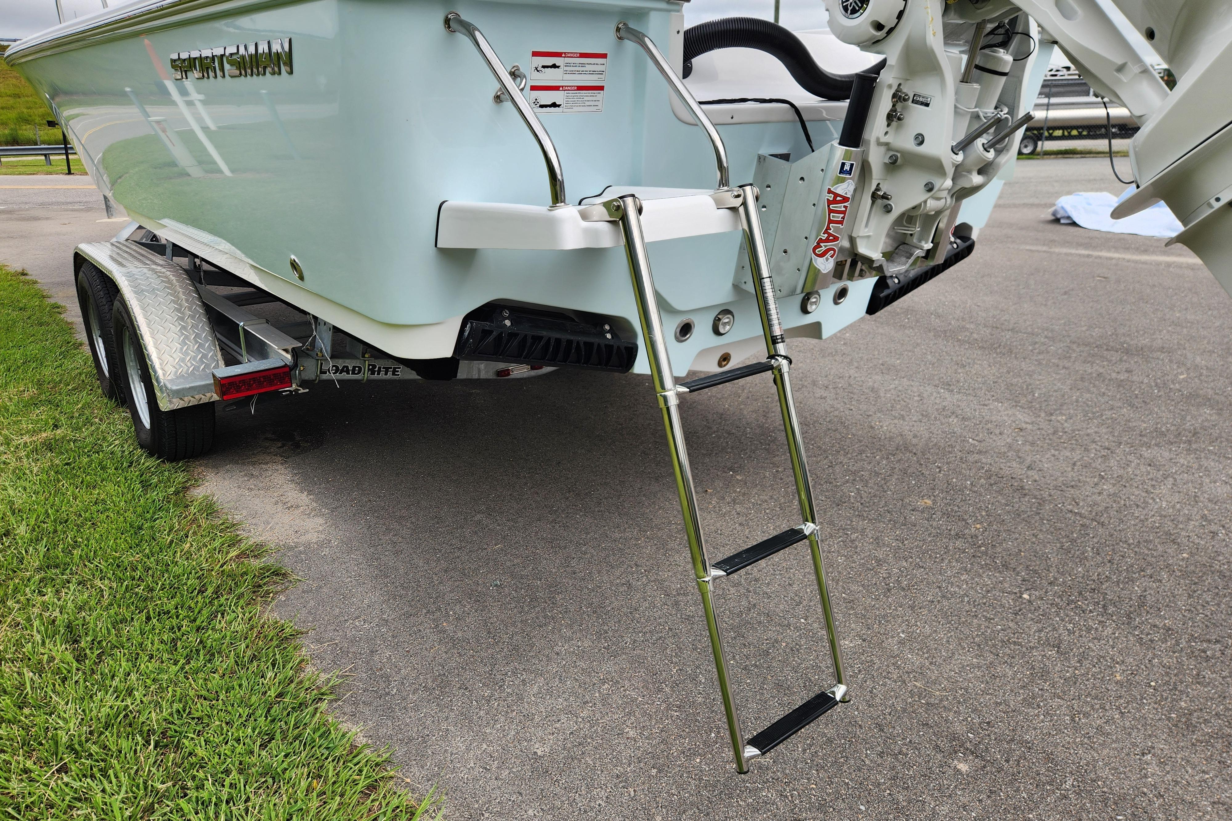 2026 Sportsman Masters 247 Bay Boat on trailer with ladder, parked on pavement.