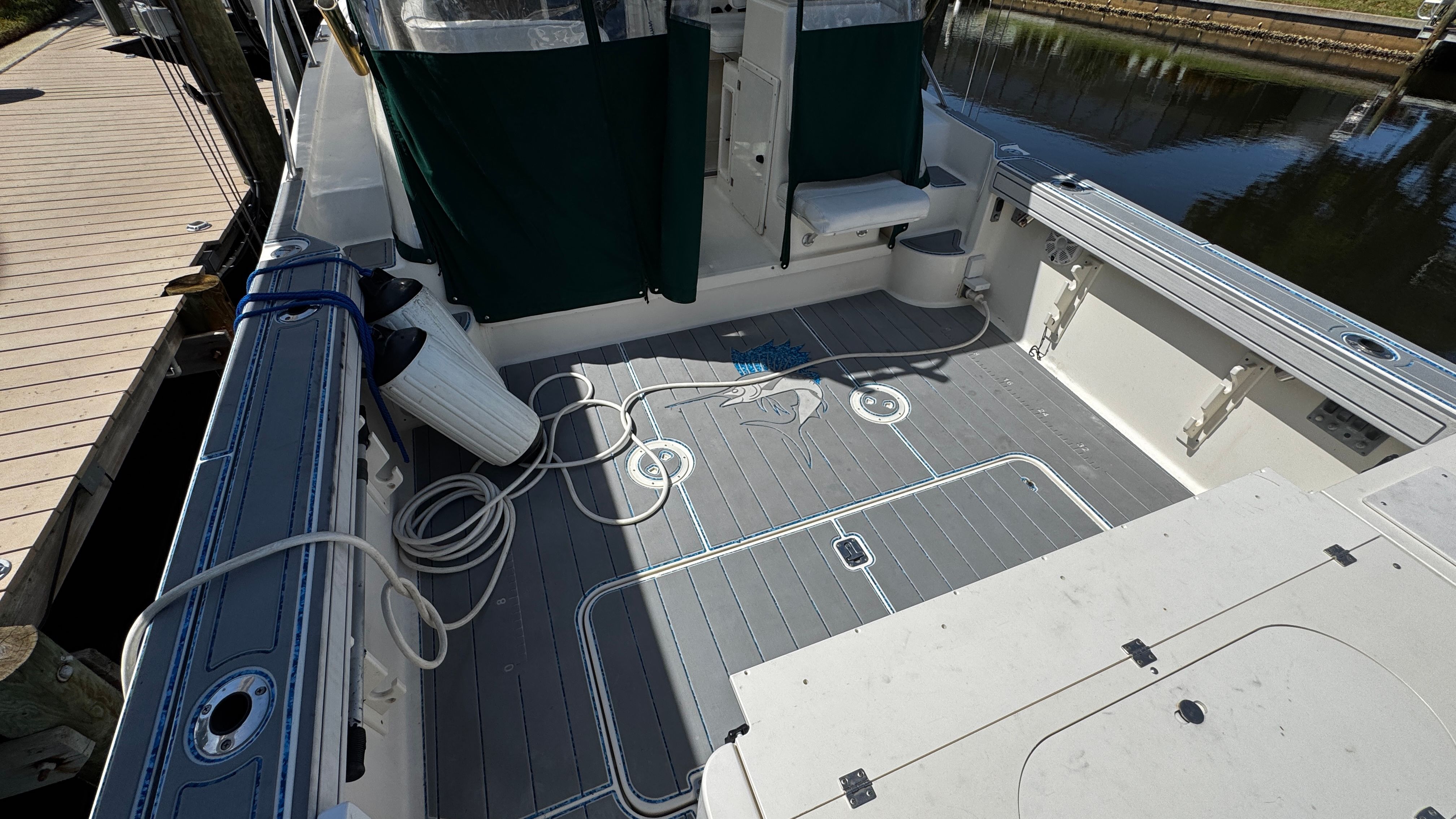 2003 Pursuit 3070 at dock with spacious deck and ropes.