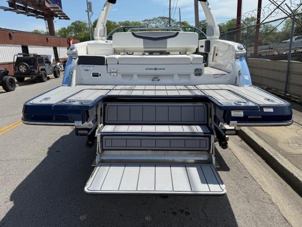2023 Chaparral 267 SSX boat with extended swim platform and steps, parked on street.