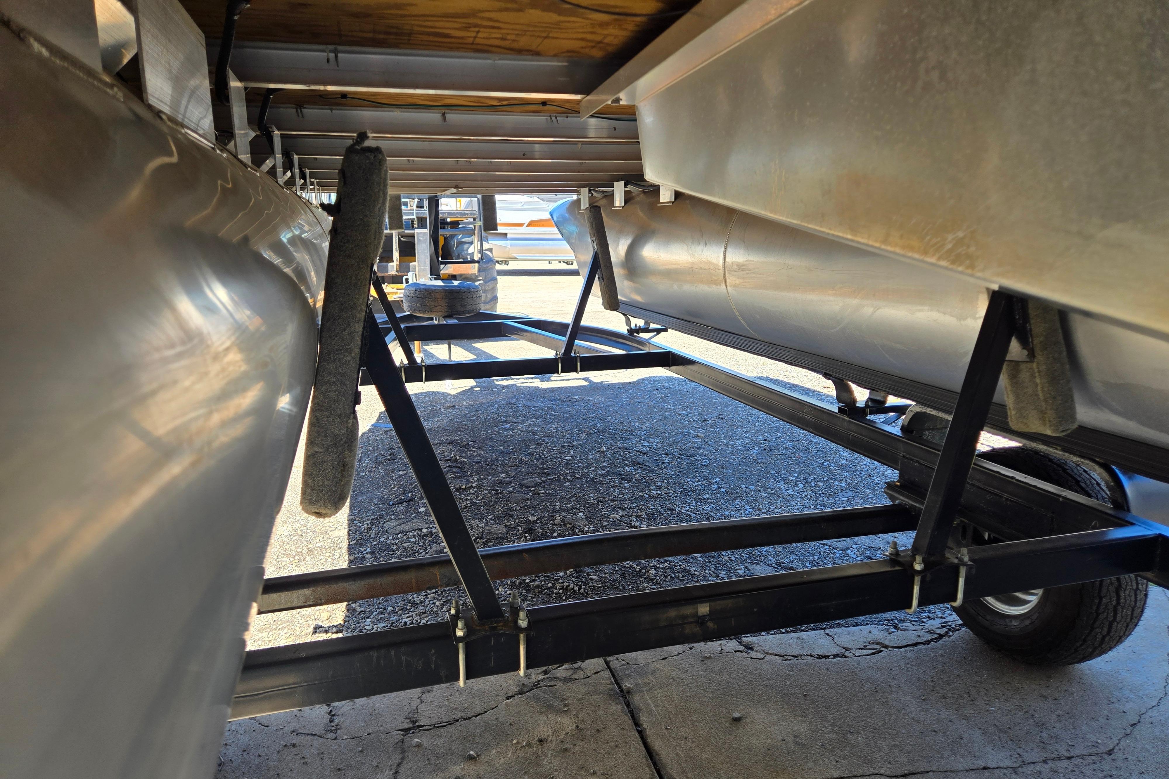 Underneath view of a 2019 Qwest Adventure 818 VX Cruise pontoon boat on a trailer.