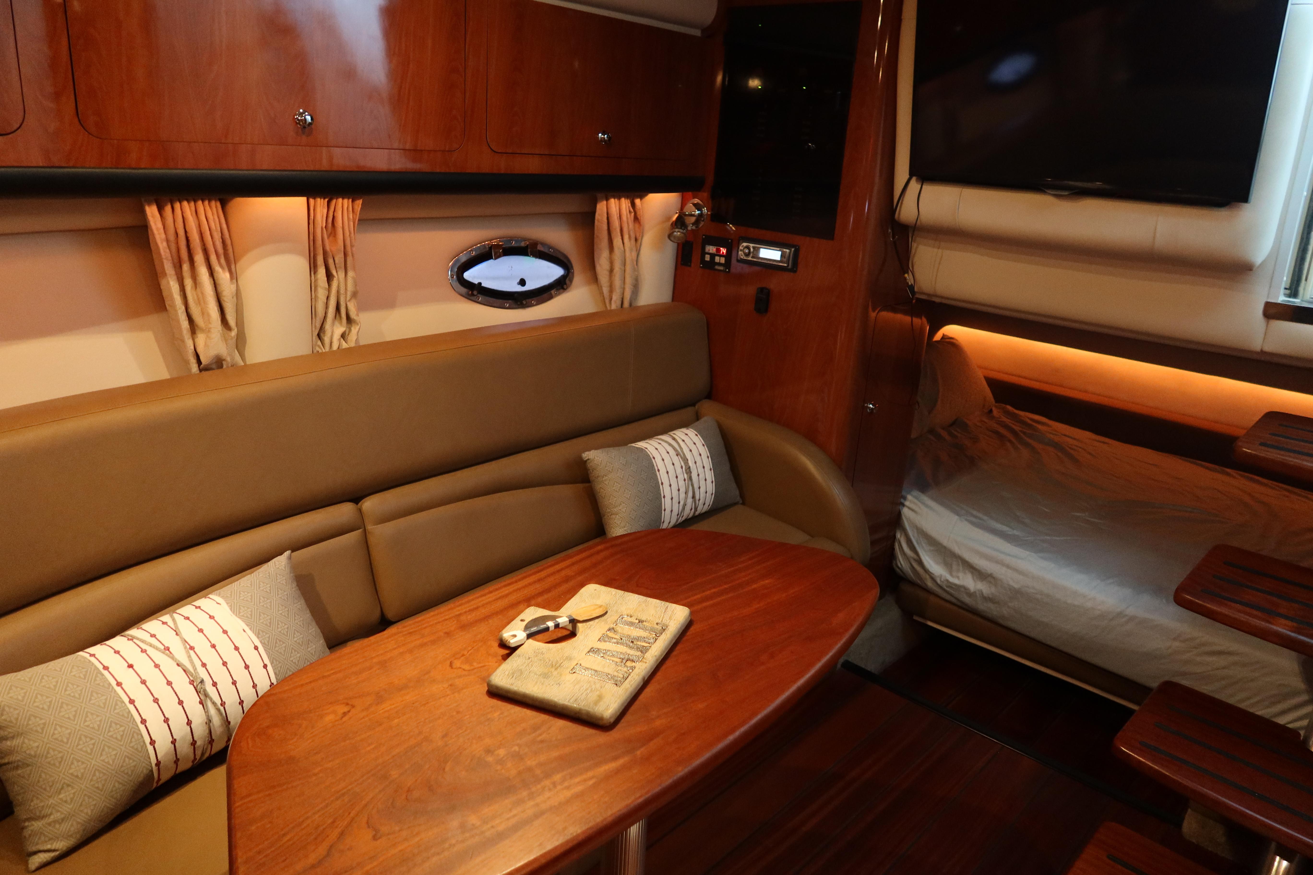 Luxurious interior of 2009 Crownline 340 CR yacht with cozy seating and elegant wood finishes.