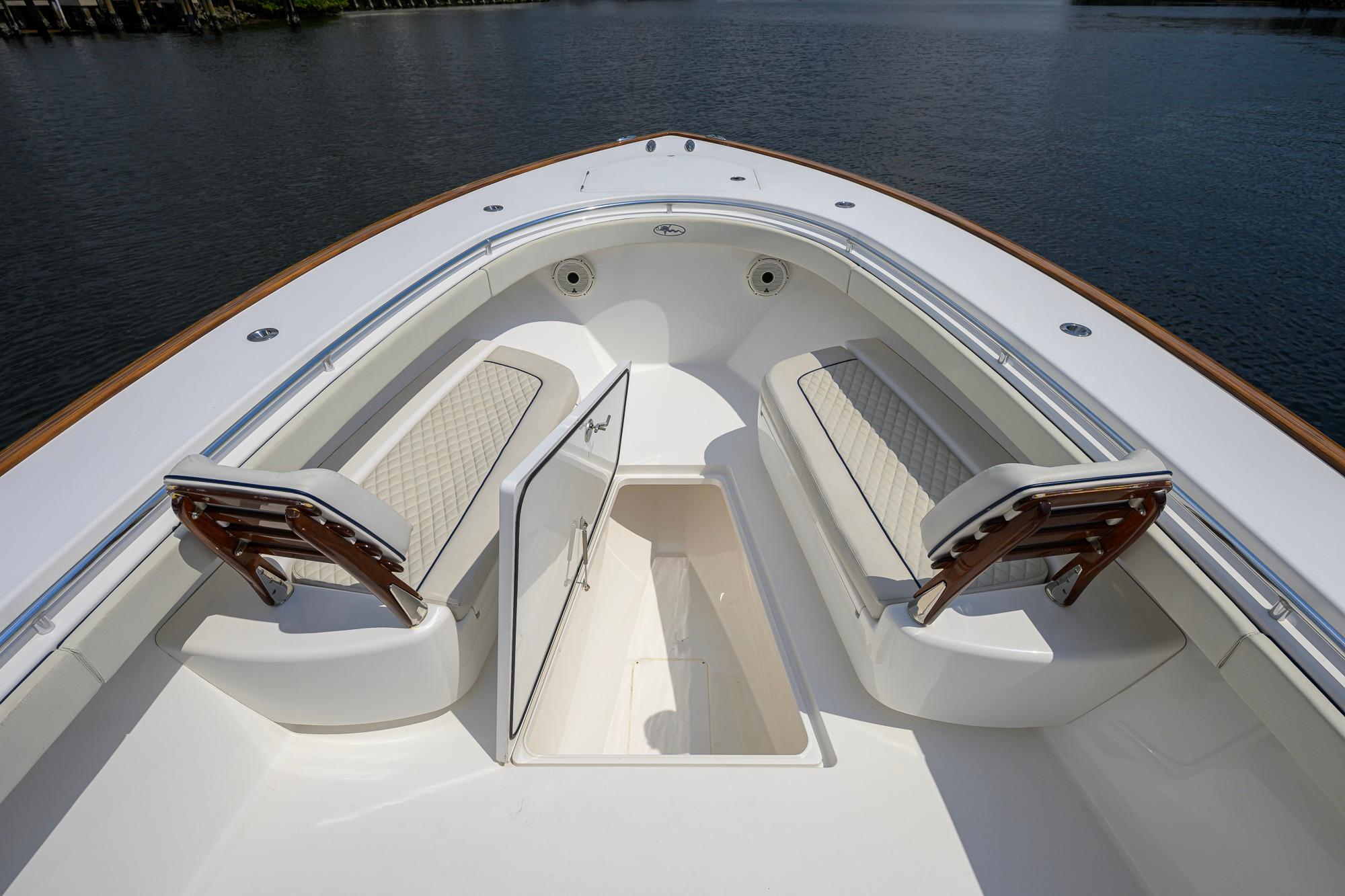 Valhalla Boatworks V-41 (2020) bow seating area with storage compartment, on calm water.