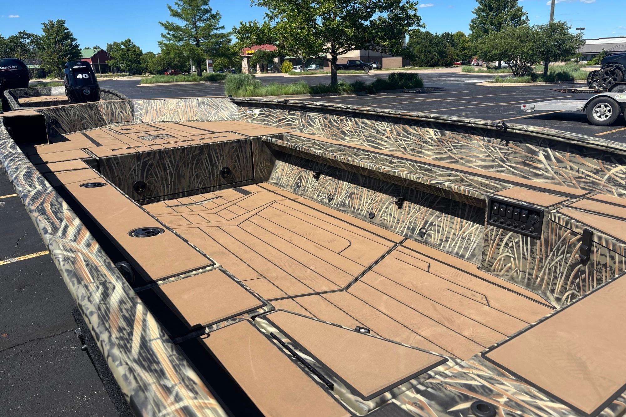 2026 Tracker Grizzly 1756 T Marsh boat with camouflage design in a parking lot.