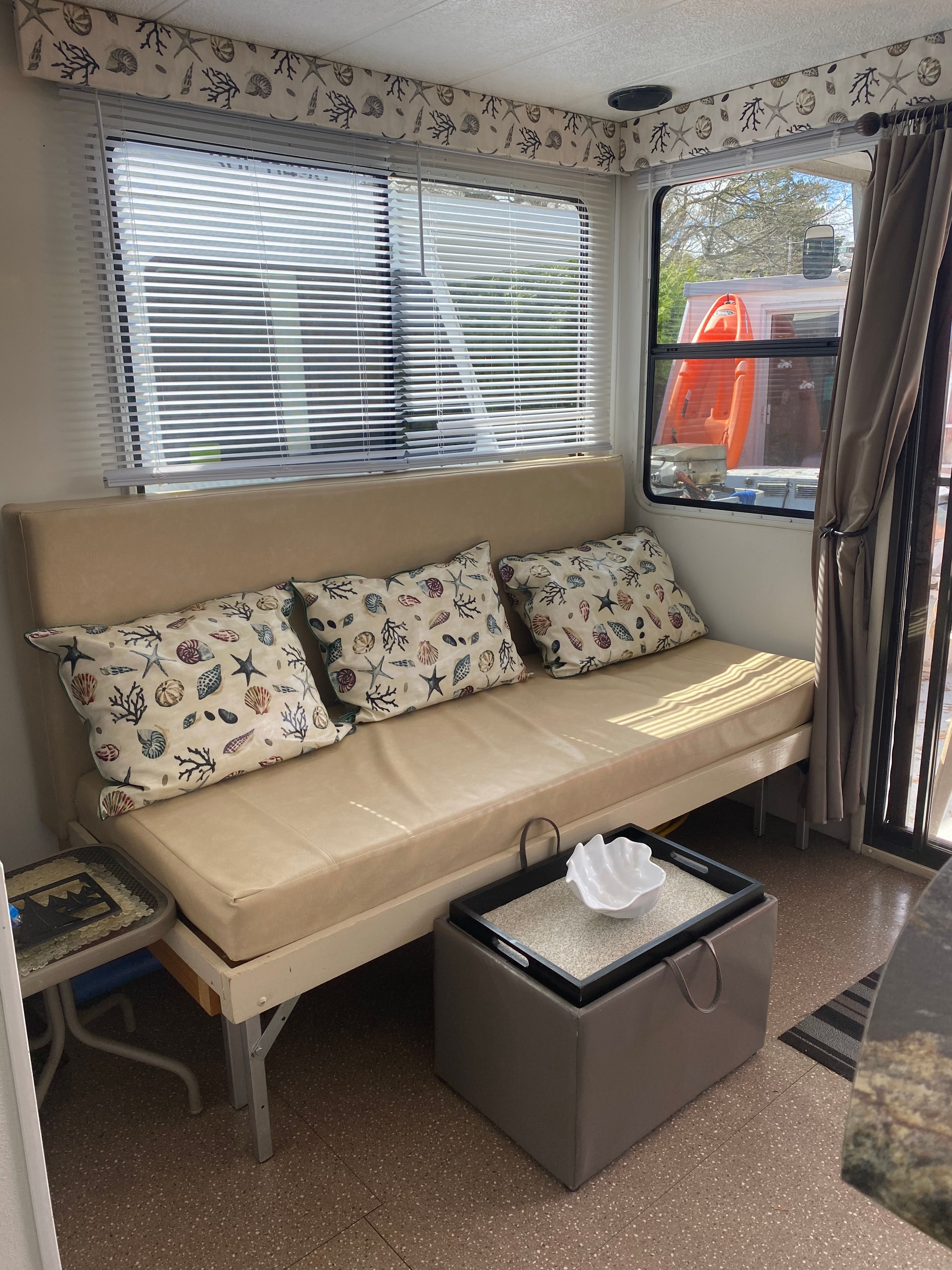 Interior of a 2004 Catamaran Cruisers with sofa and cushions, windows with blinds.