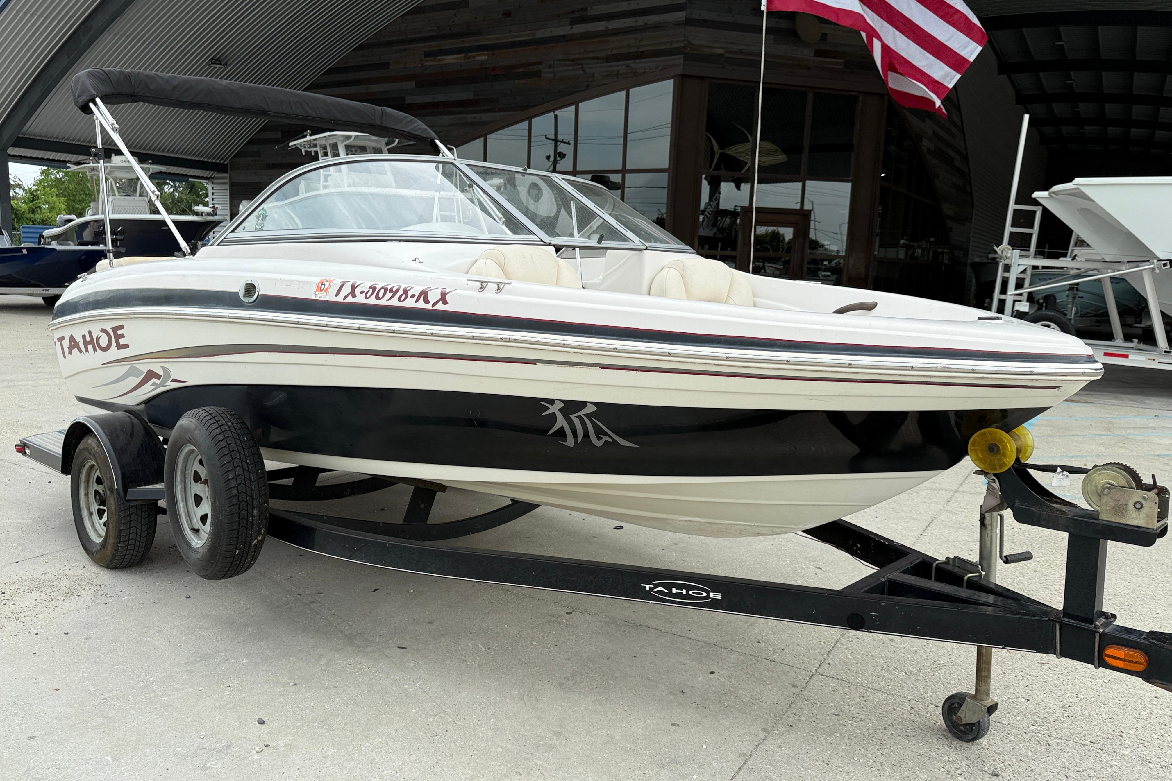 2010 Tahoe Q4 boat on trailer with American flag in background.