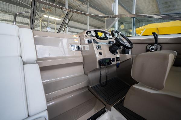 2016 Regal 28 Express boat interior with steering wheel and control panel in a marina setting.