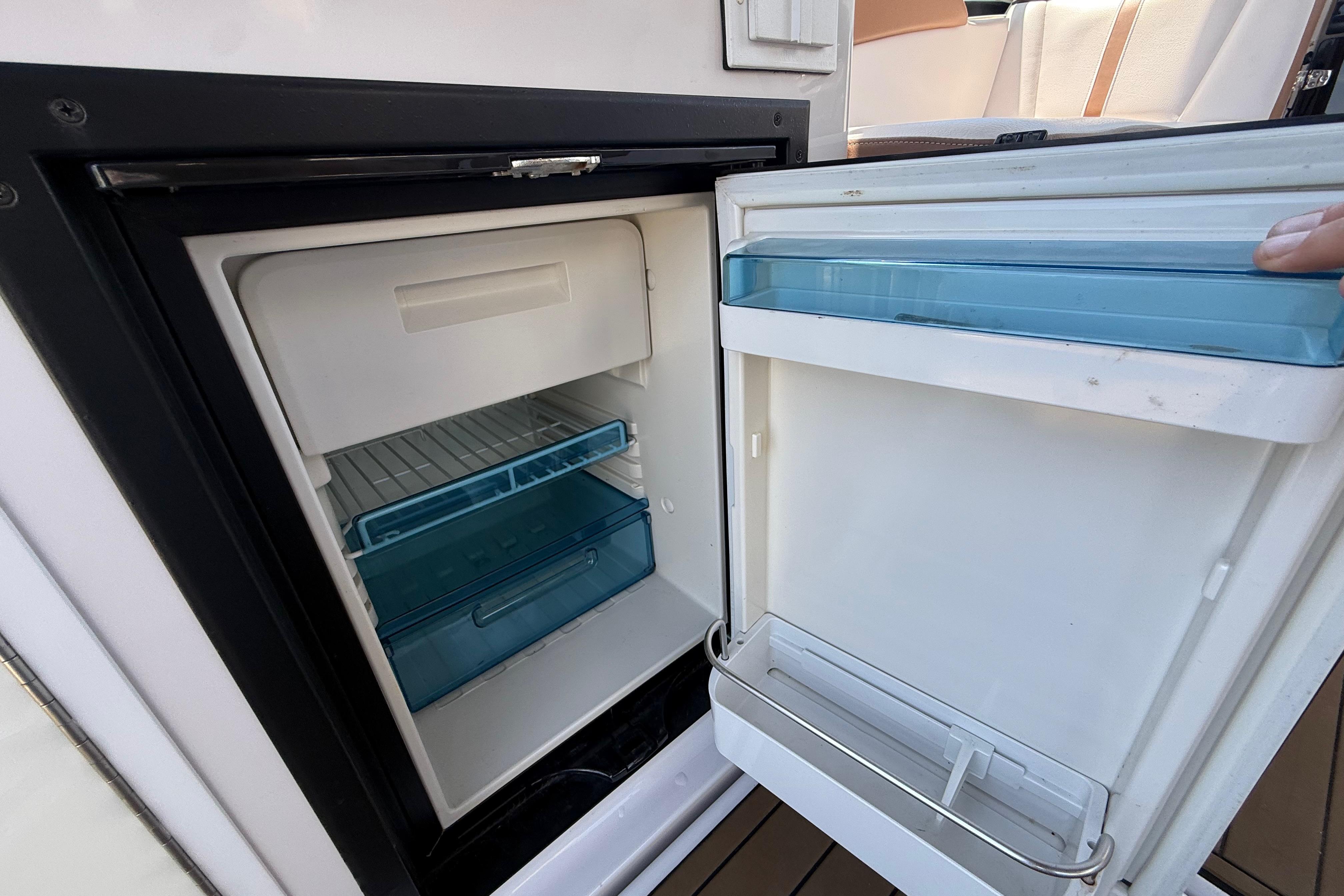 Open refrigerator on 2017 Four Winns V275 boat, showing interior shelves and door compartments.