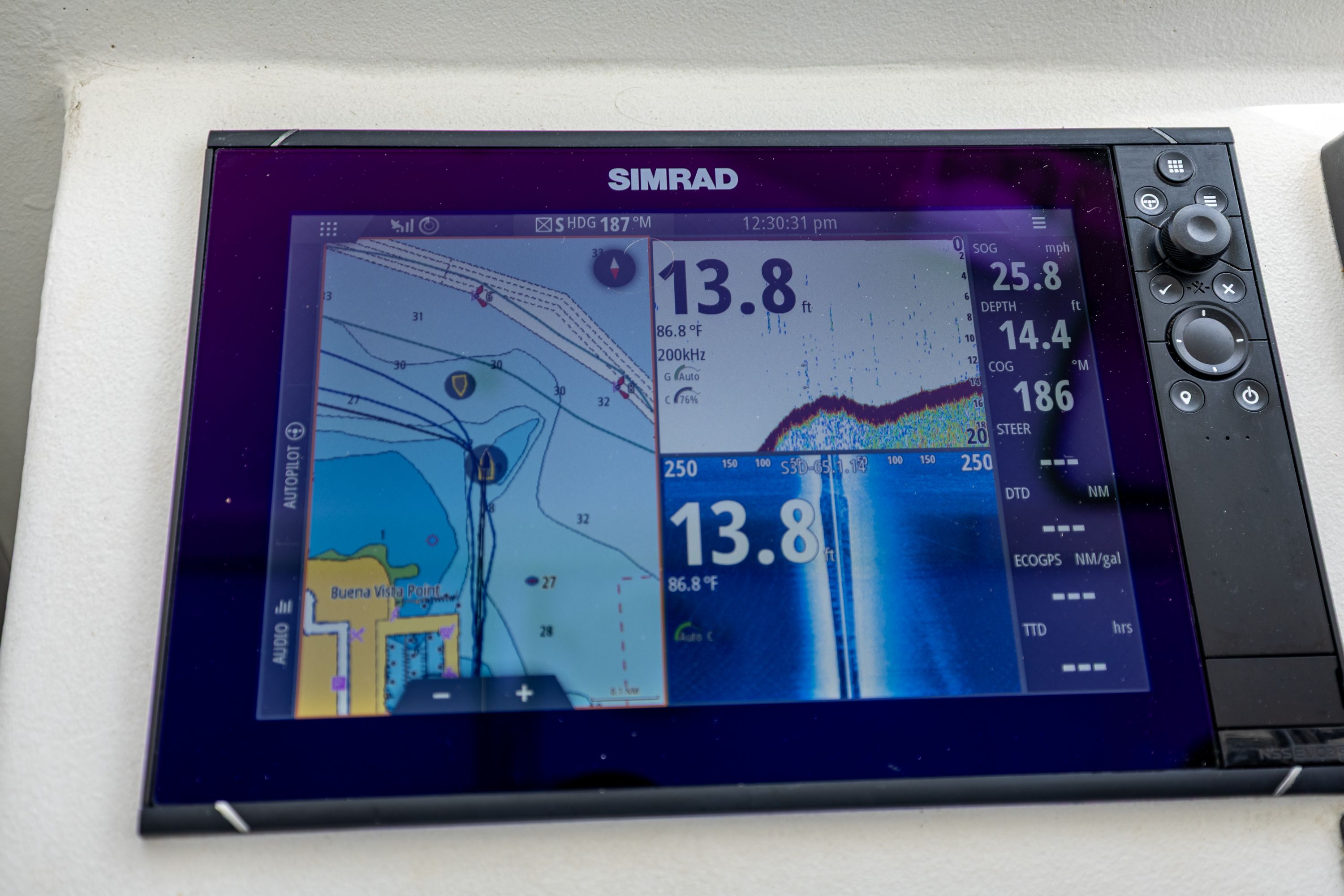 Simrad navigation system on a boat displaying chart and sonar readings.