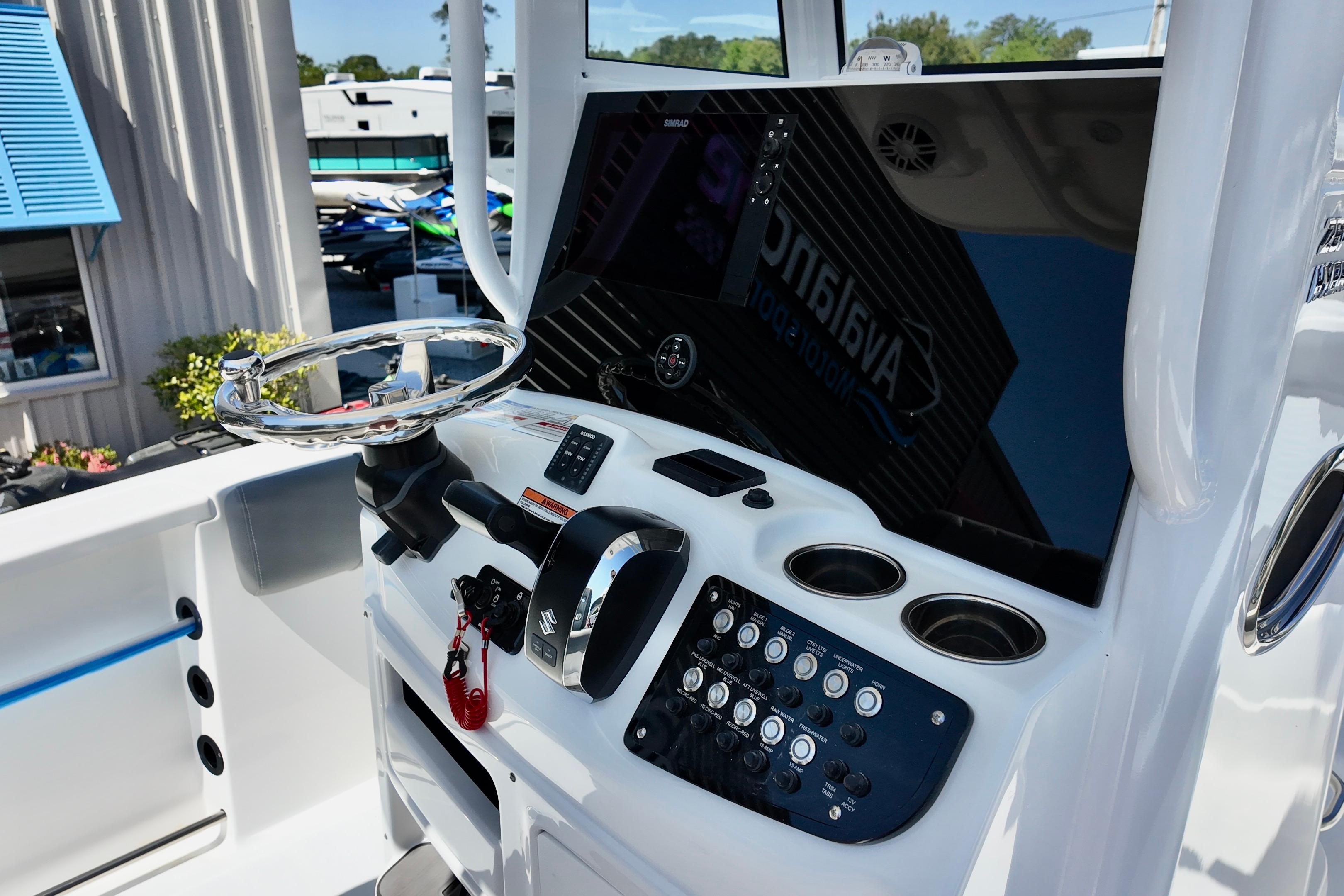 2026 NauticStar 251 Hybrid boat dashboard with steering wheel and control panel.