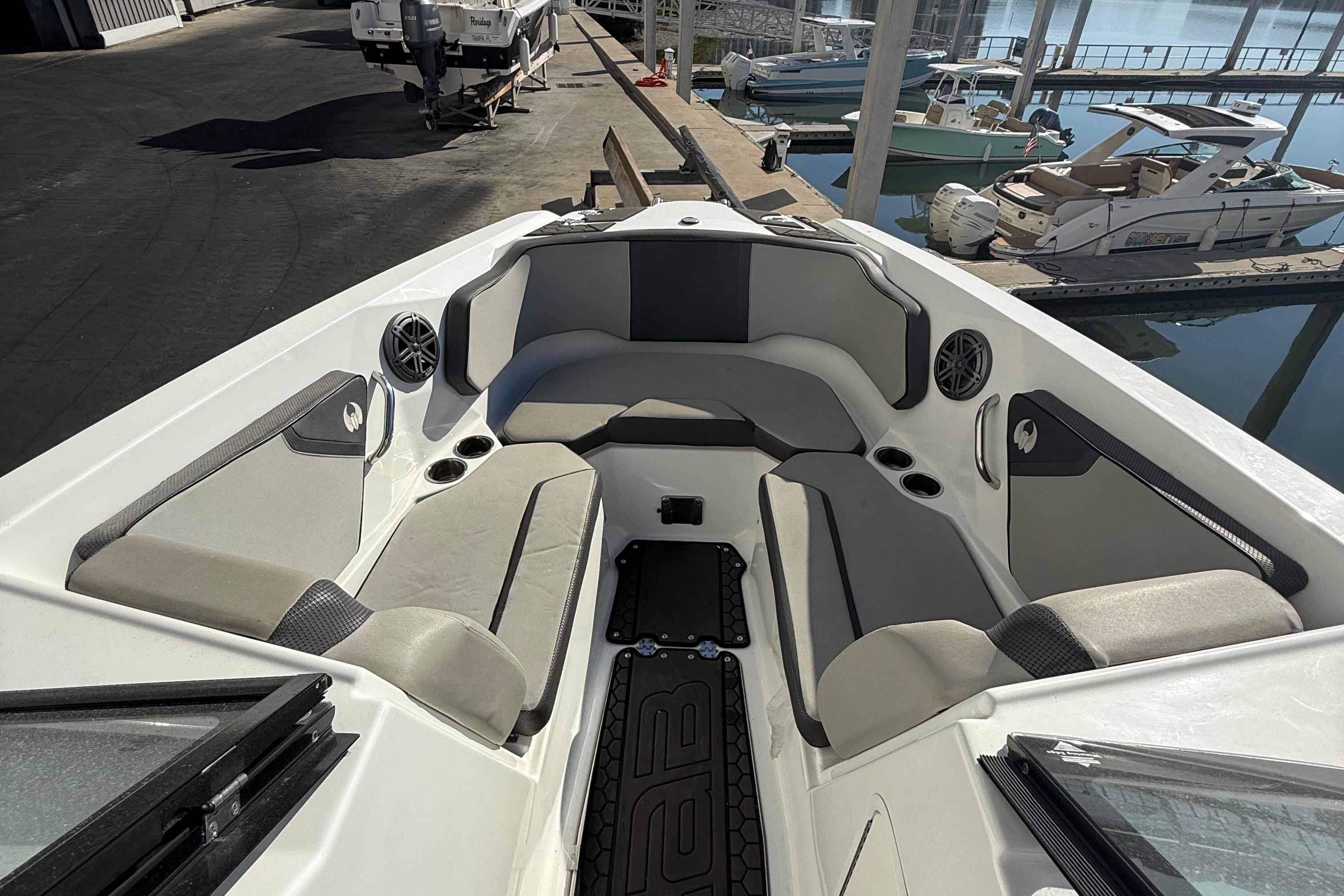 2021 Scarab 255 ID boat interior with cushioned seating and cup holders at a marina.