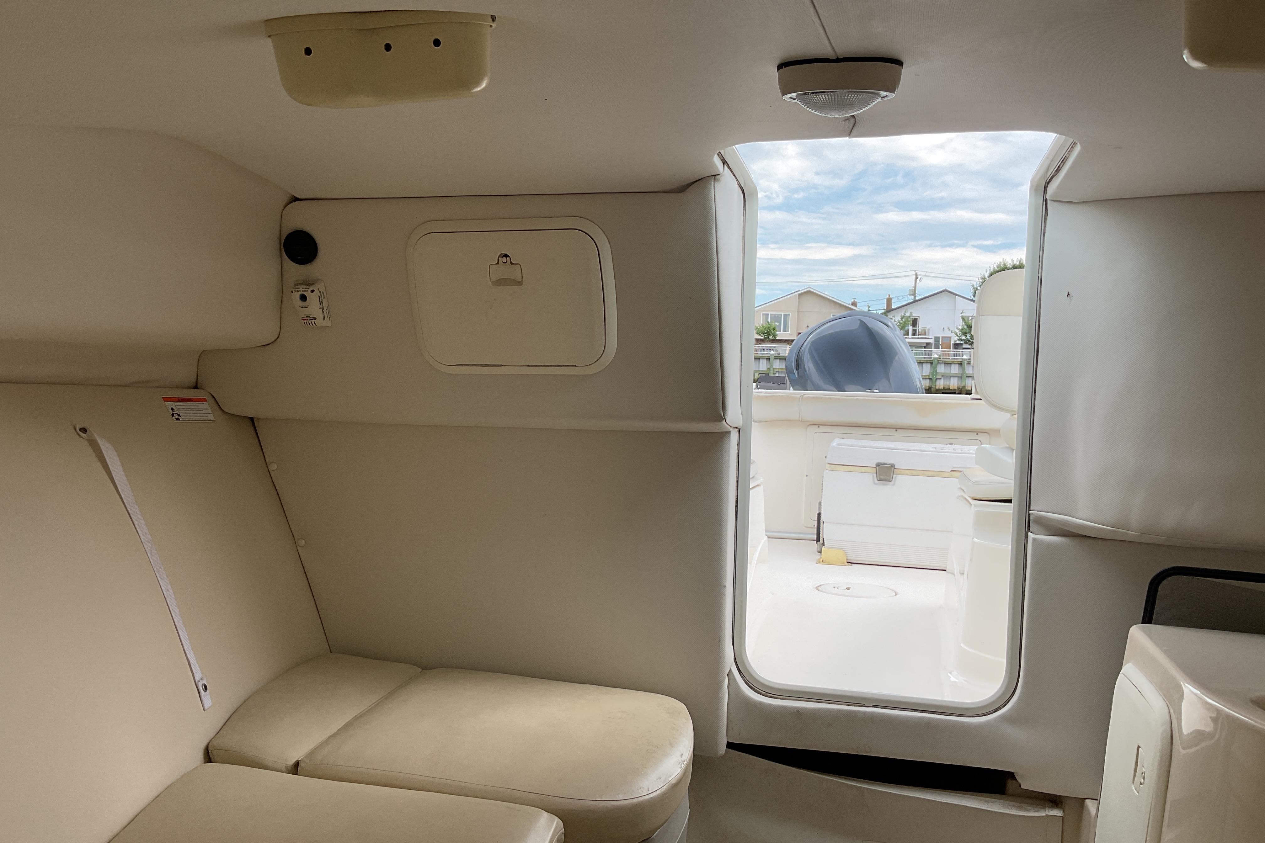 Interior view of 2012 Wellcraft 232 Coastal boat cabin with seating and storage.